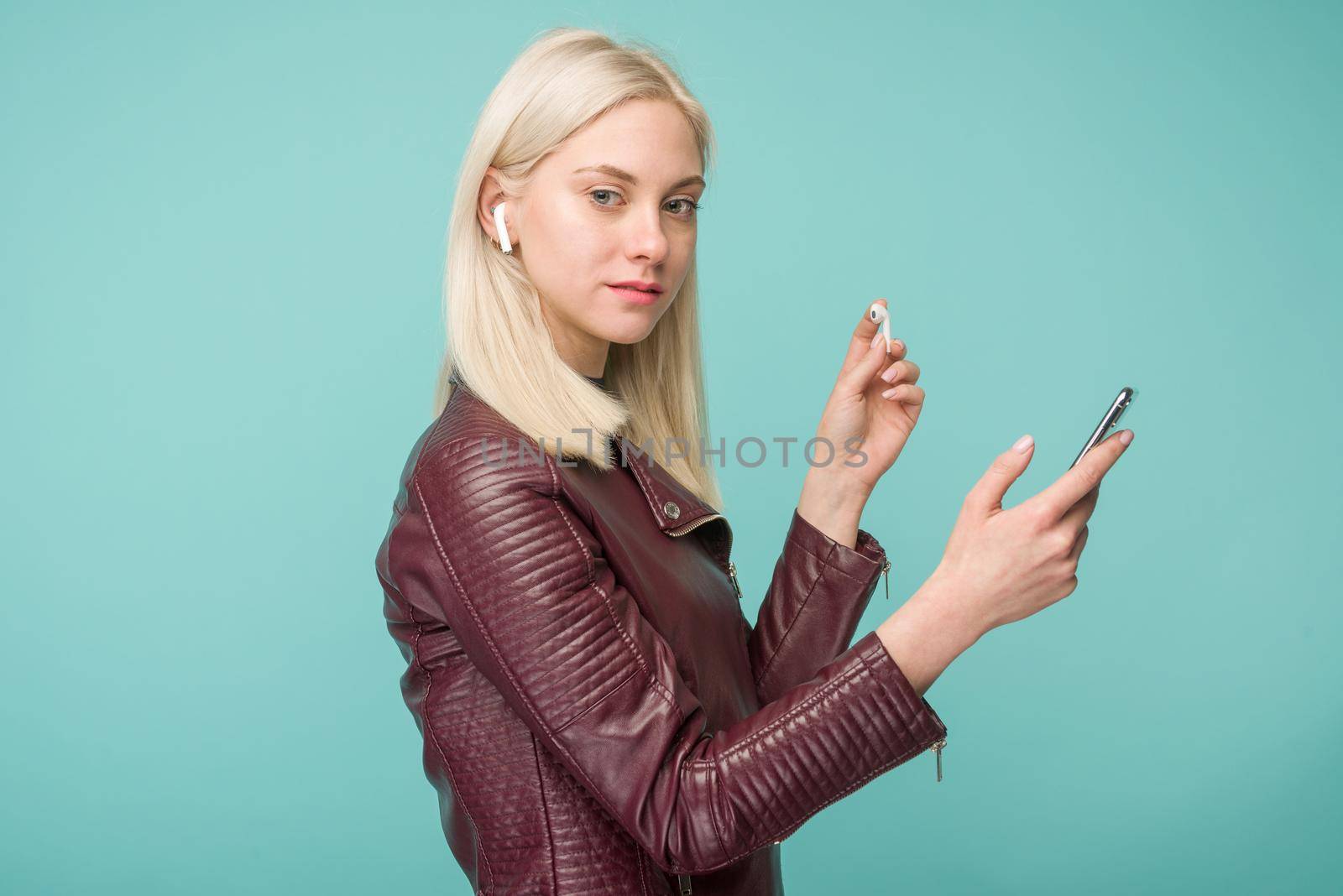 Tula, Russia - May 1, 2019: Happy woman listening music Apple AirPods wireless . by zartarn