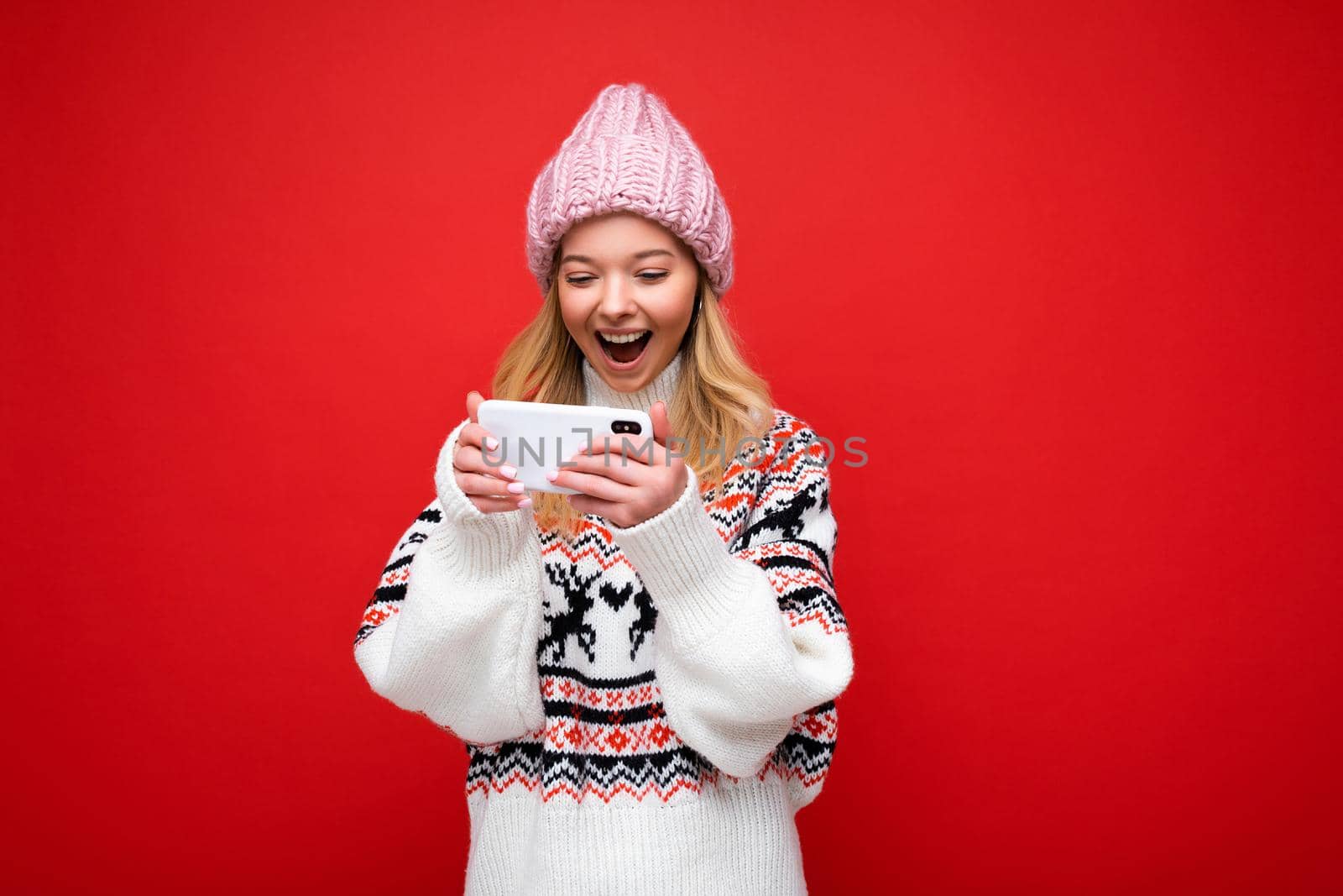 Photo of attractive crazy amazed surprised young woman wearing casual stylish clothes standing isolated over background with copy space holding and using mobile phone looking at screen display.