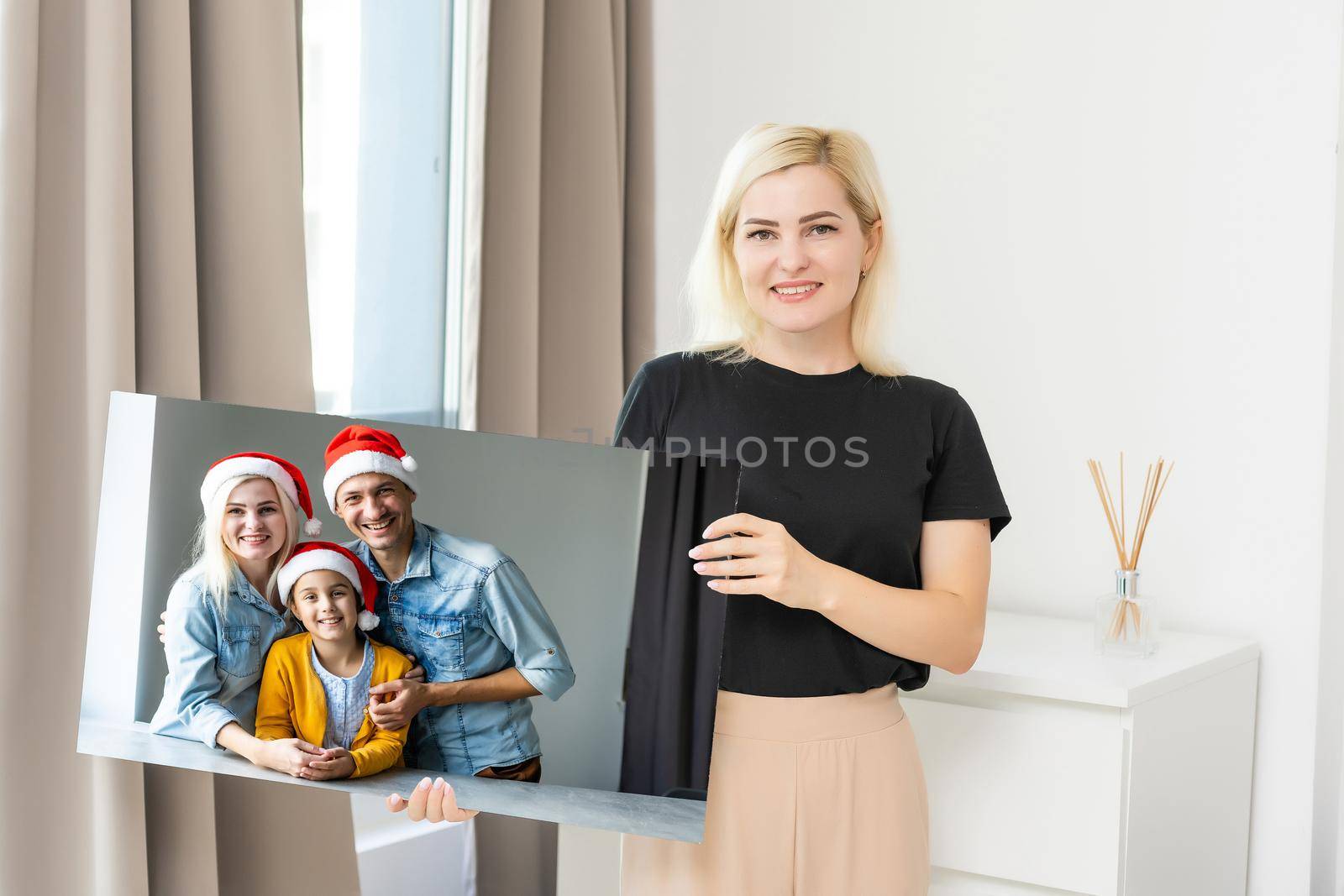 woman holding a photo canvas with a picture of christmas.