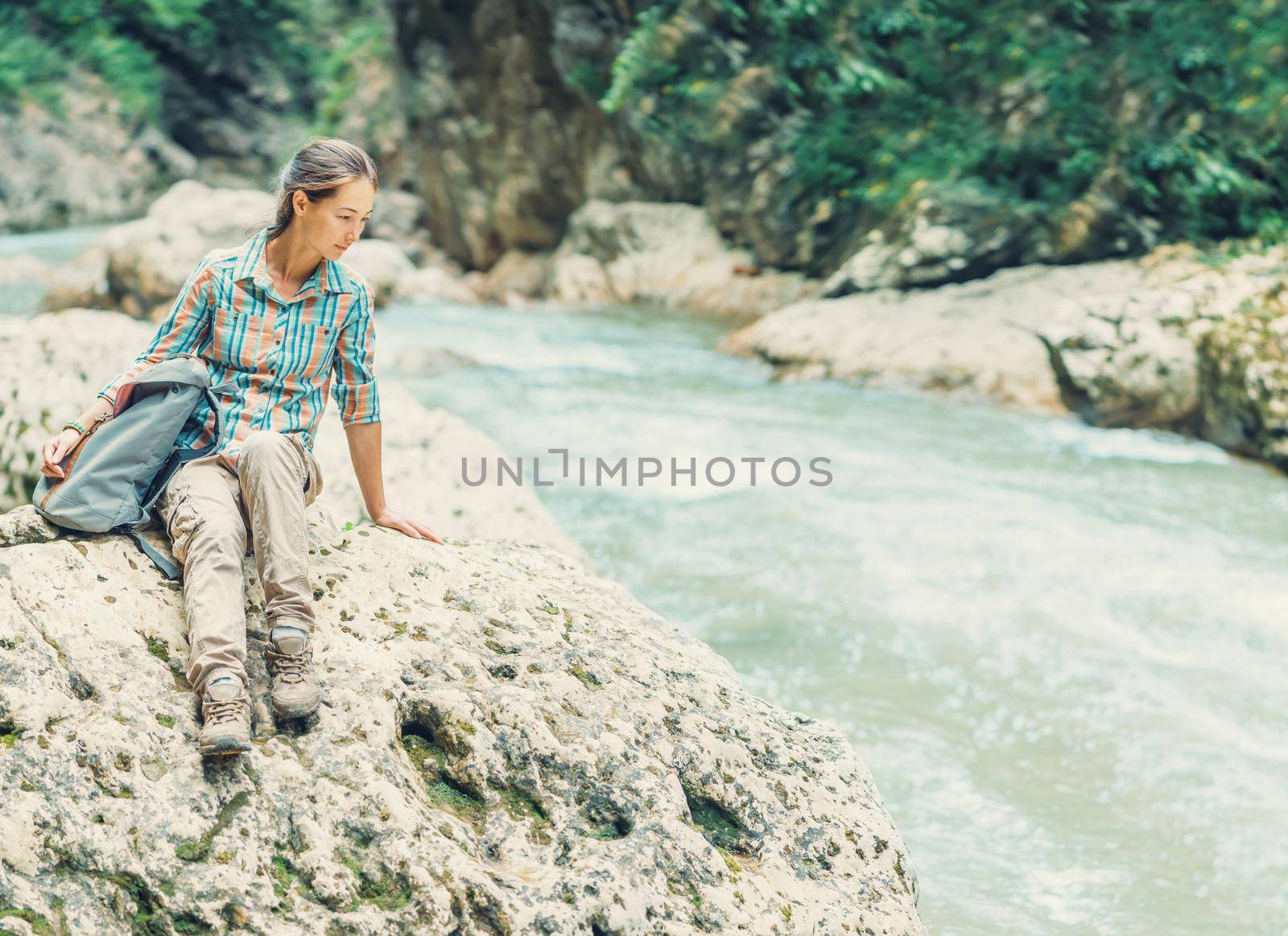 Female explorer resting near the river by alexAleksei