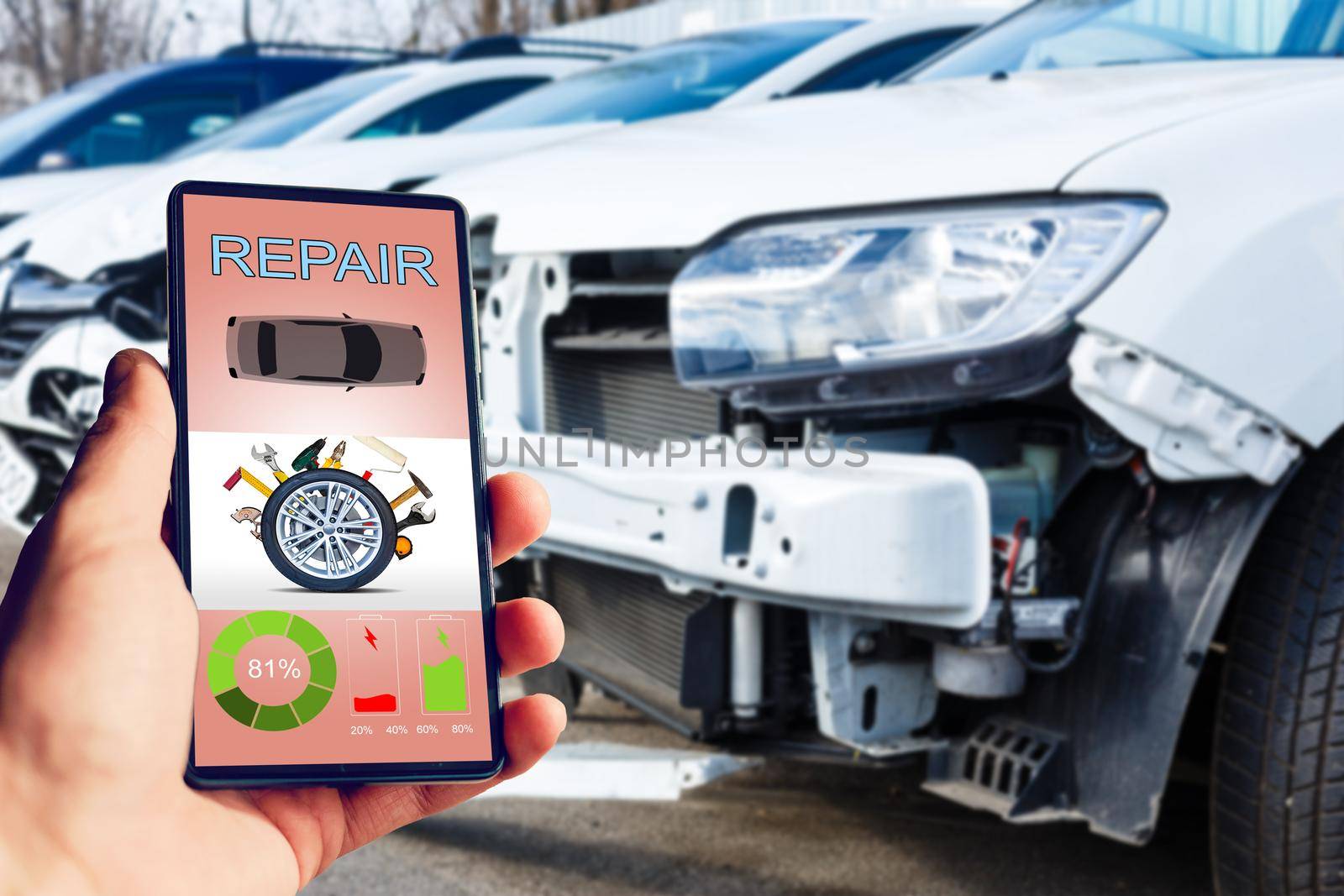 Mobile phone in hand on car repair service center blurred background.