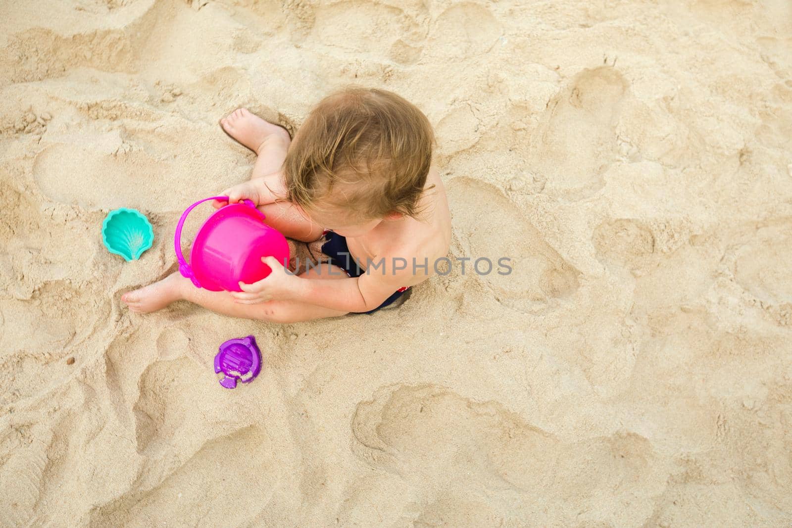 Kid playing with toys on sand by Demkat