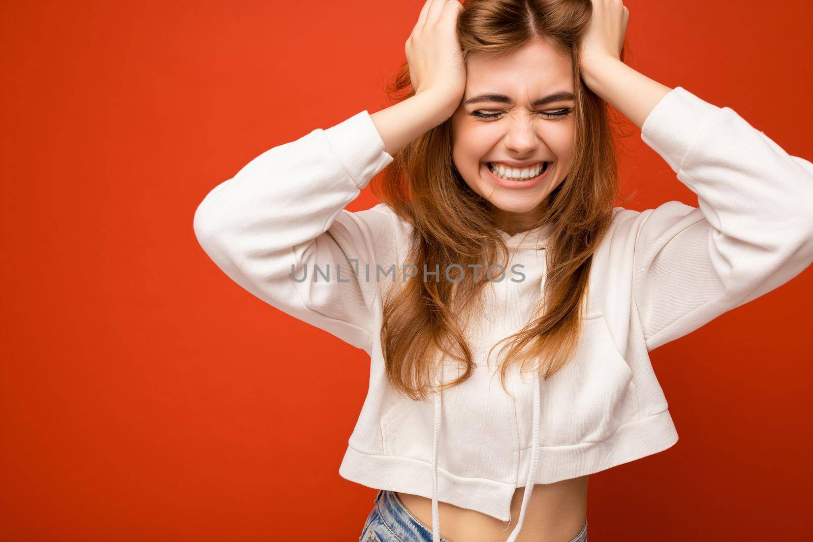 Photo of attractive cute happy emotional young woman poising isolated on background wall with free space wearing trendy casual clothes.