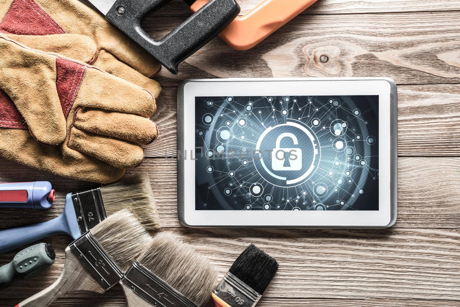 Tablet pc with security concept on screen and industrial tools around