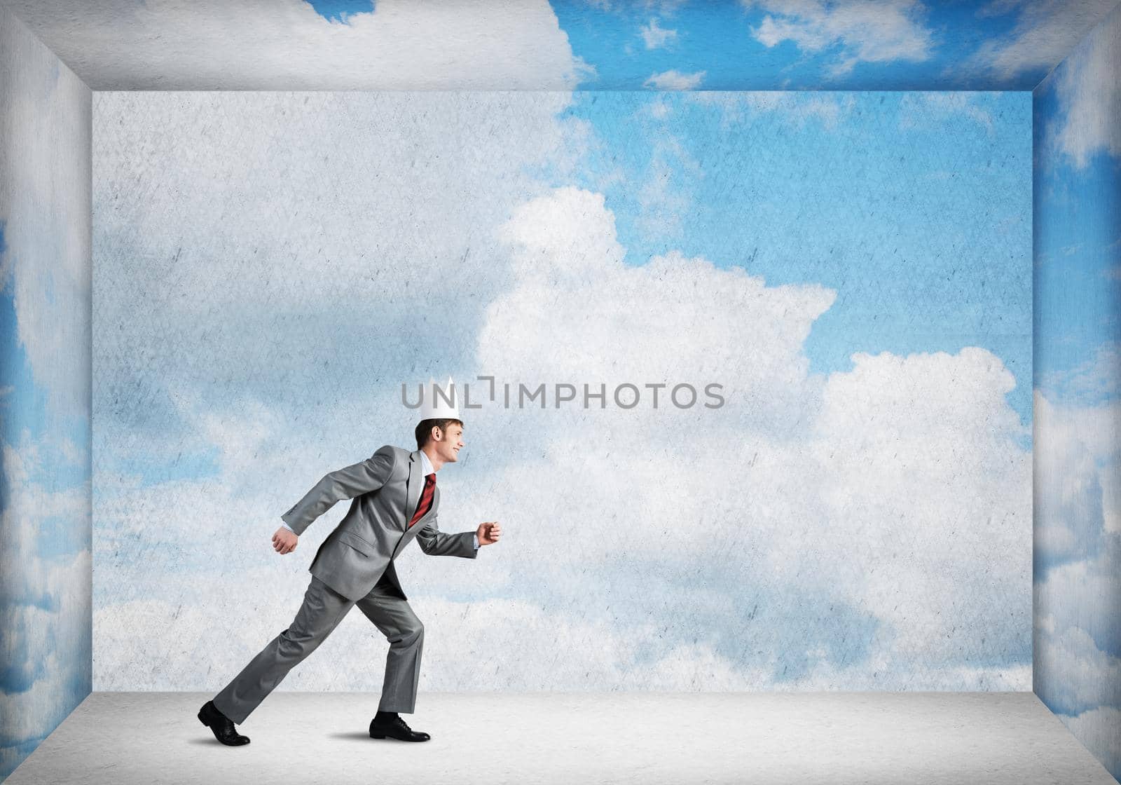 Young handsome businessman wearing white paper crown running in a hurry