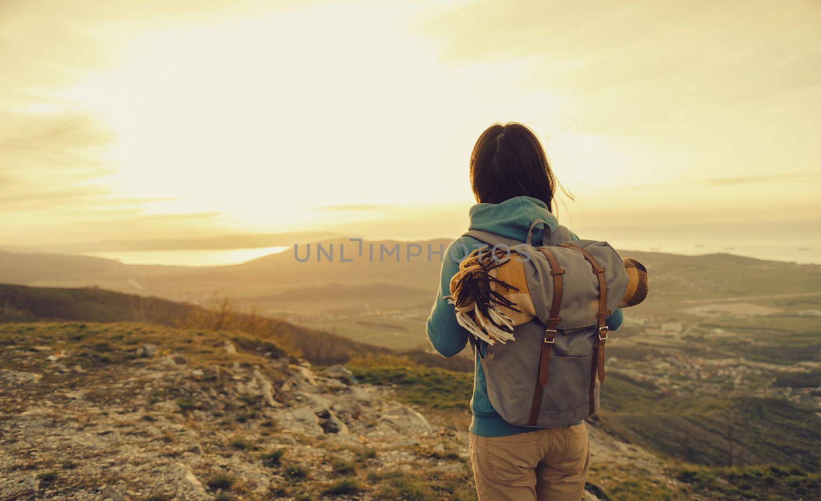 Traveler explorer young woman walking in mountains at sunset