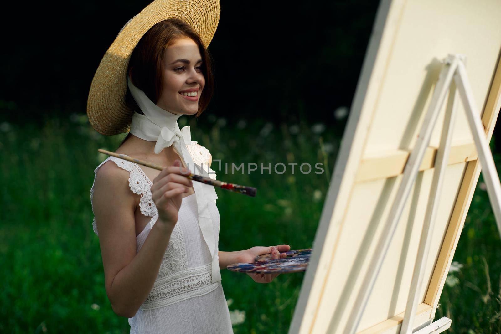 Woman in white dress artist easel painting nature landscape. High quality photo