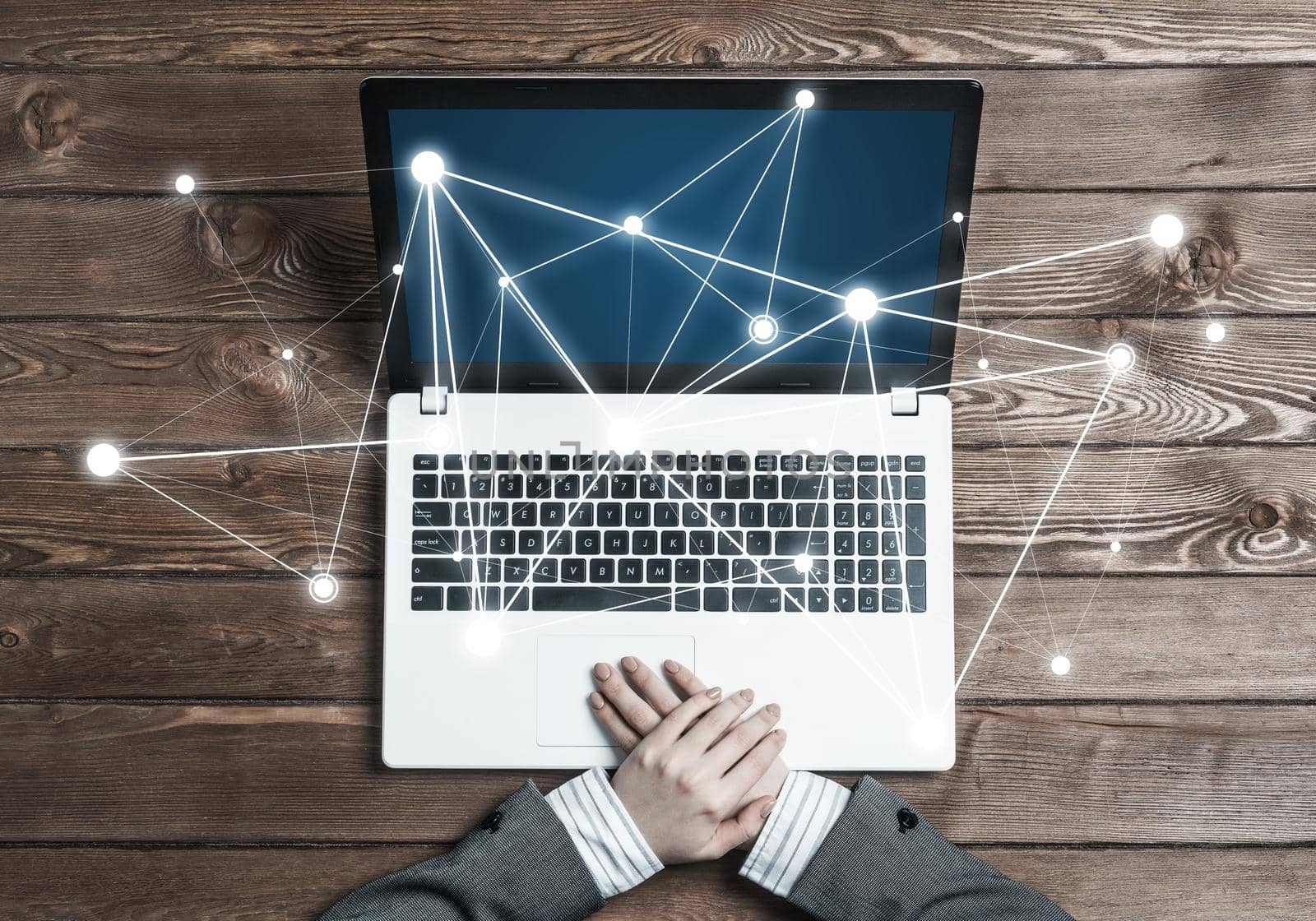 Top view of laptop on wooden surface and businesswoman hands