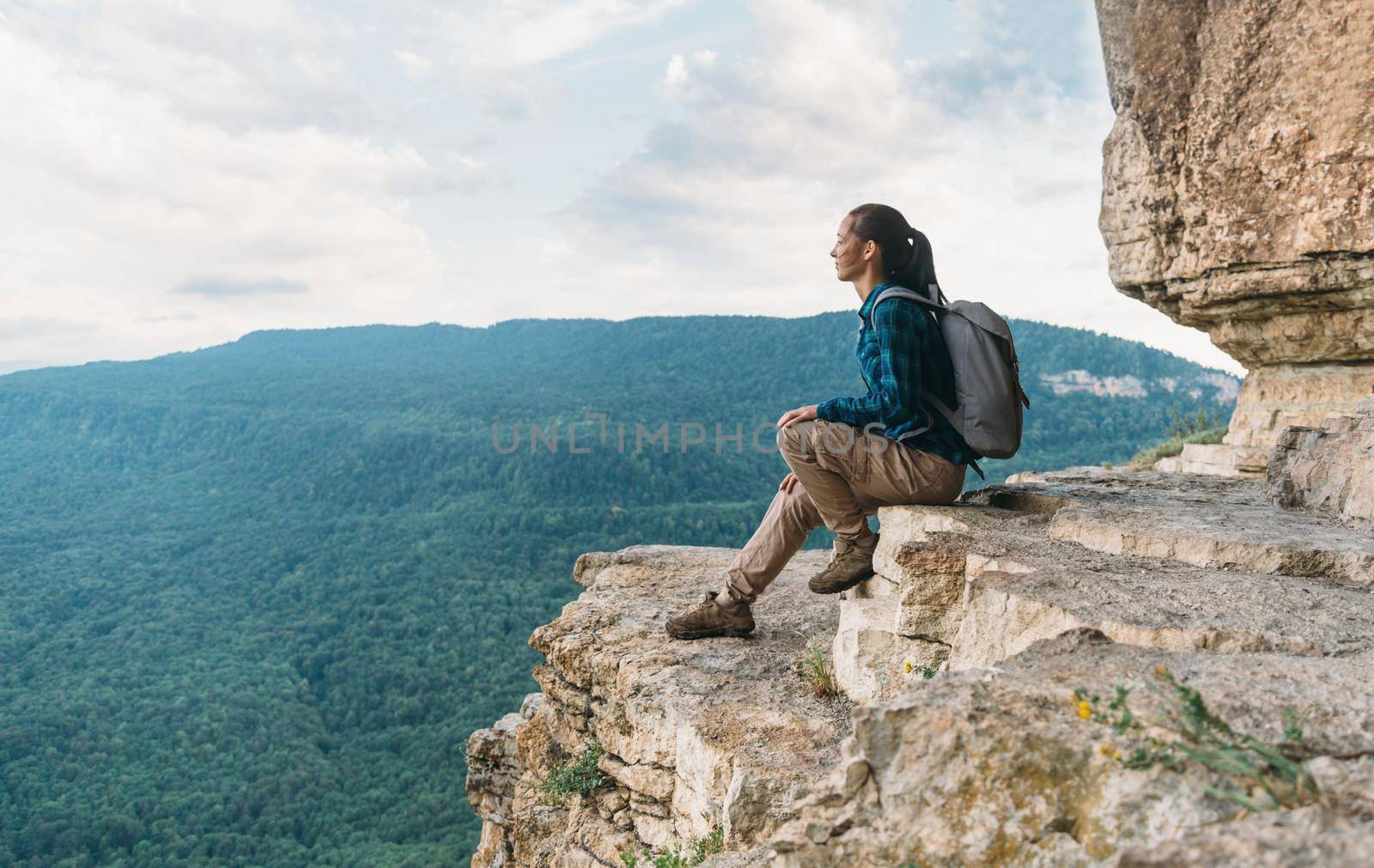 Explorer sitting on cliff by alexAleksei