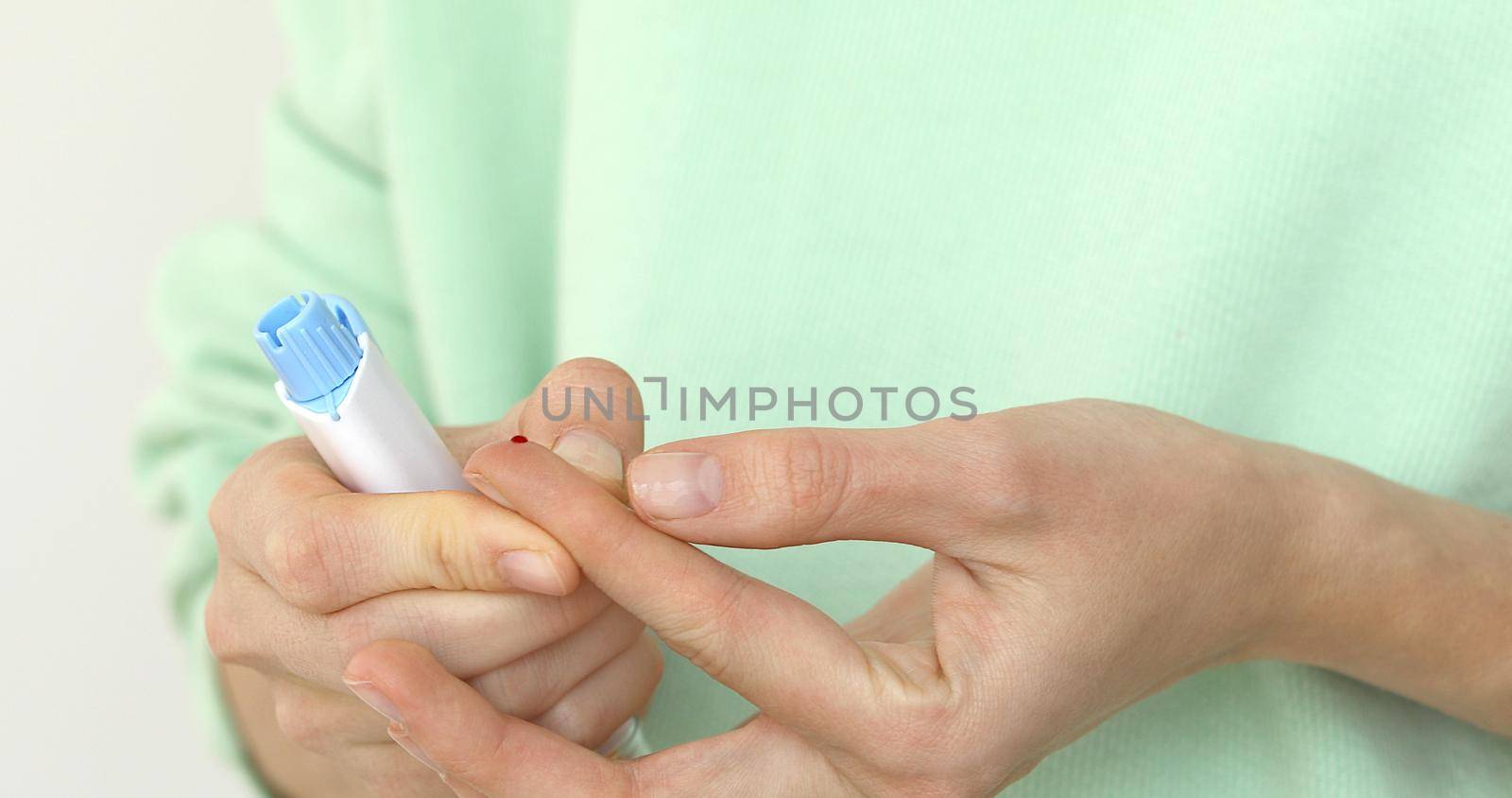Woman self-testing for diabetes. Girls diabetic puncture finger to measure blood