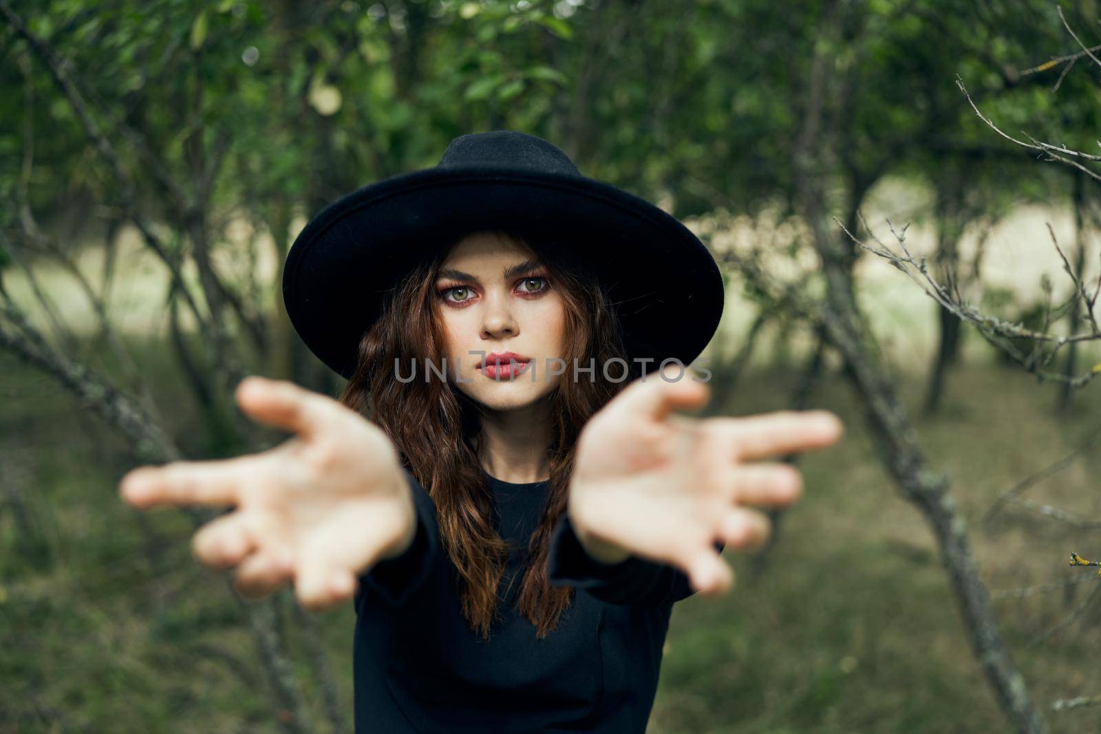 woman in black witch costume in forest nature posing by Vichizh