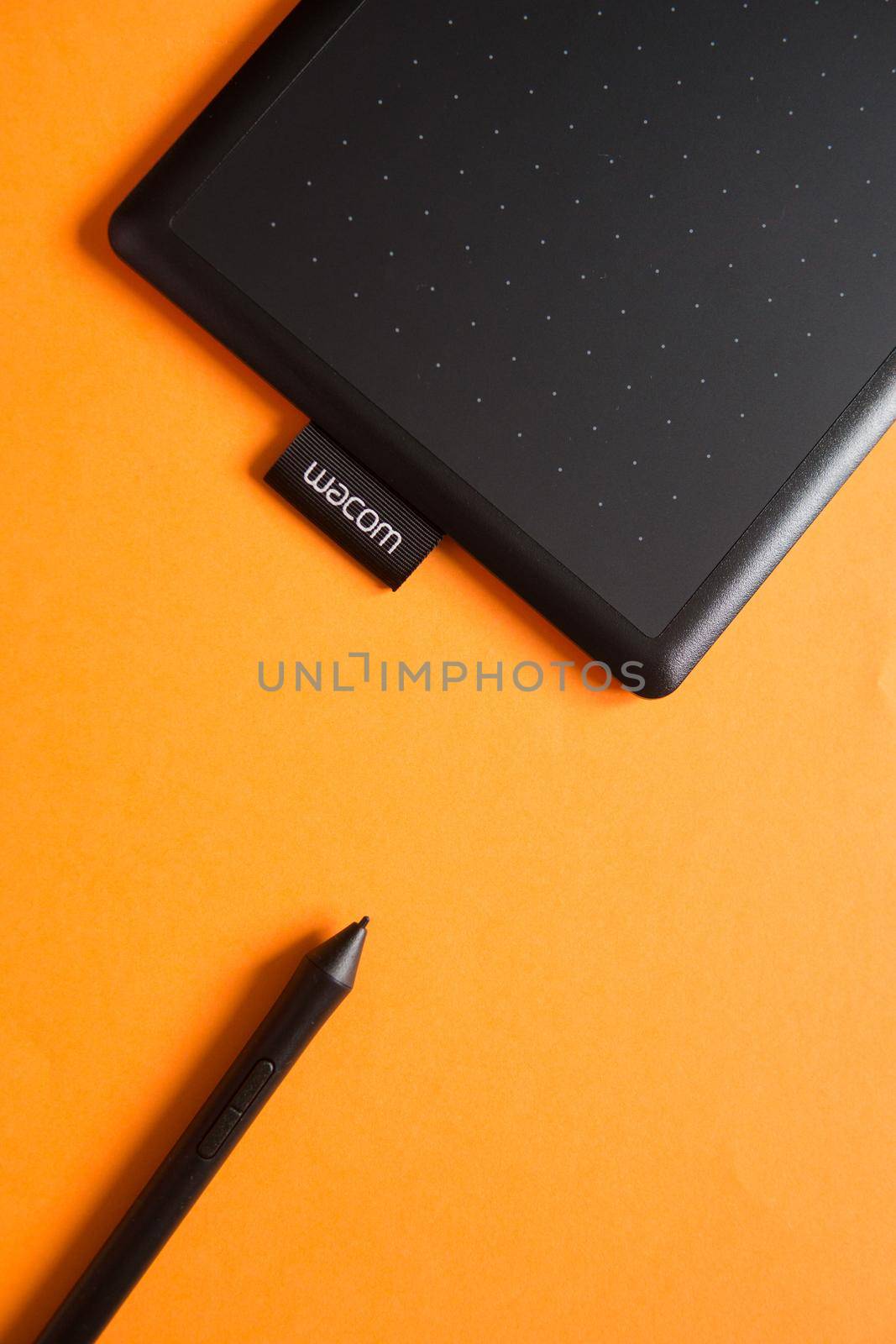 Tver, Russia - February 3, 2020; Top view of Wacom graphic tablet on orange background. Space for text. Selective focus.