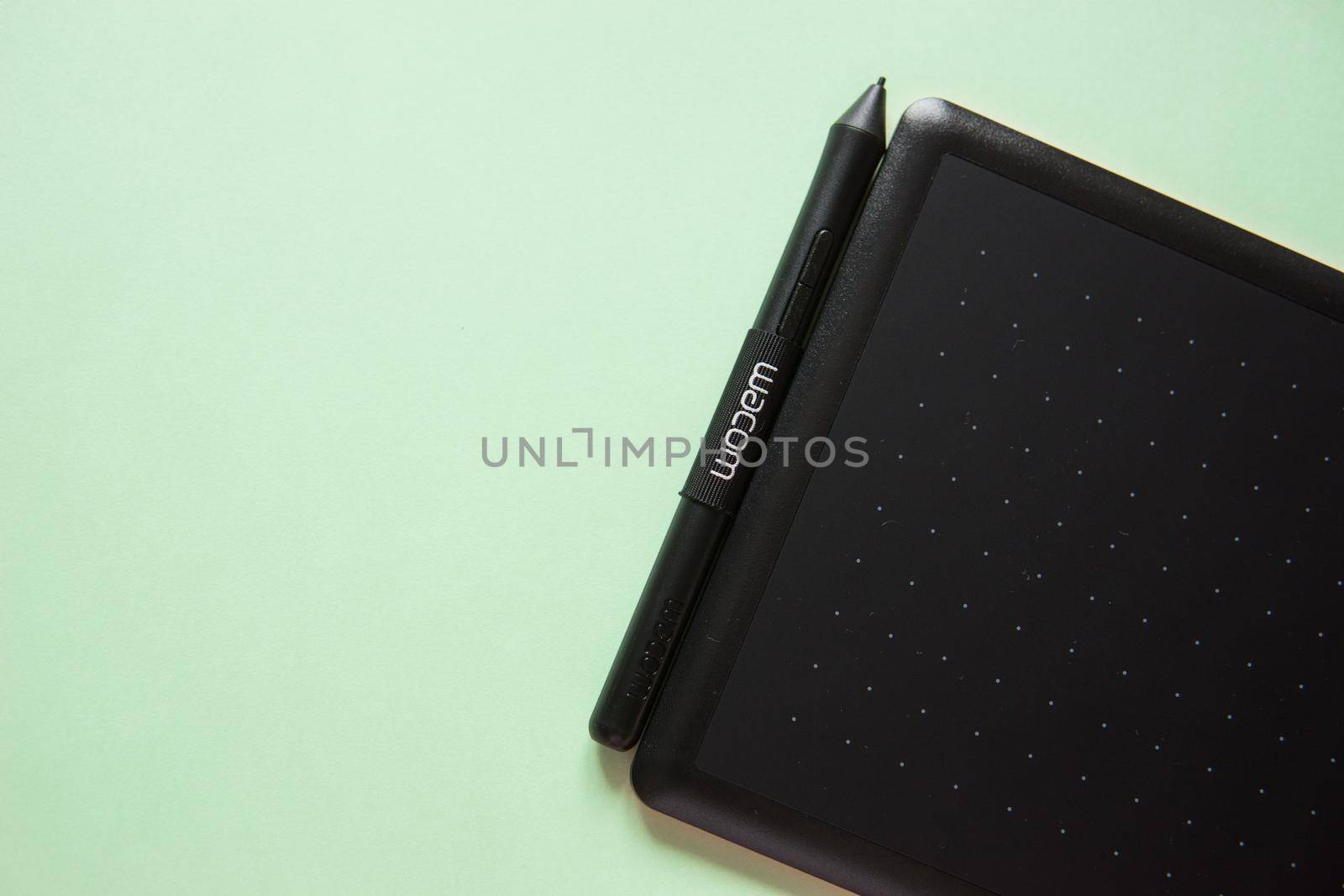 Tver, Russia - February 3, 2020 Top view of Wacom graphic tablet on pastel green background. Space for text. Selective focus.