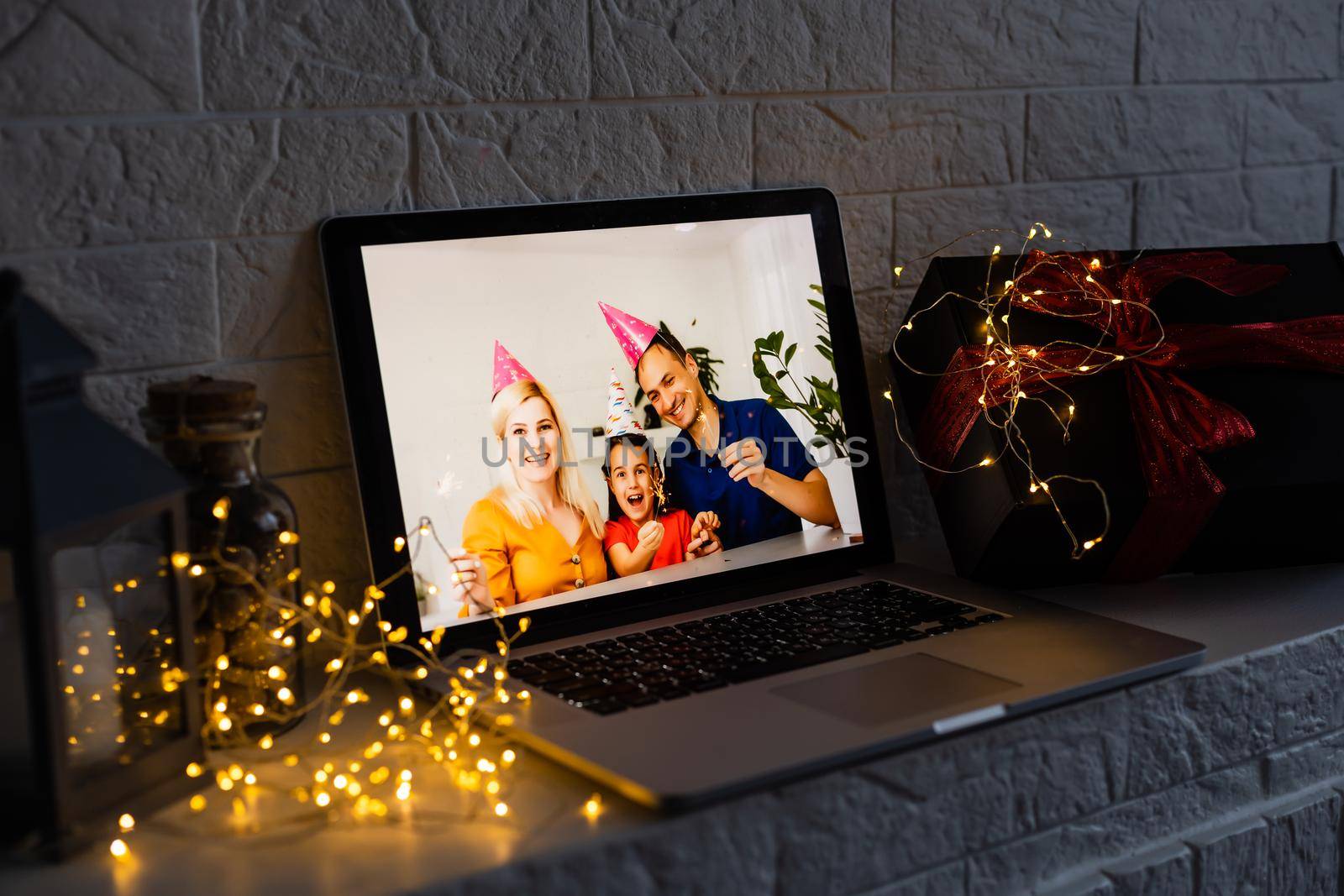 Image of open laptop family and christmas on wooden table in front of christmas tree background.