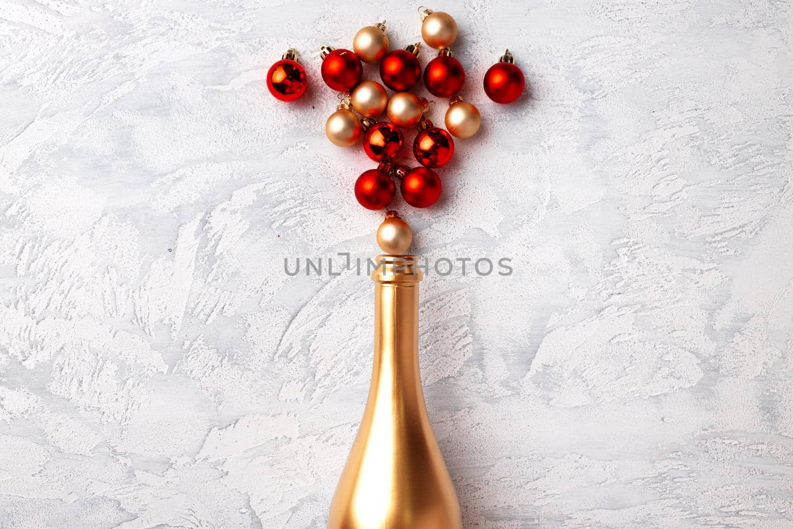 Flat lay composition with gold champagne bottle and Christmas balls top view
