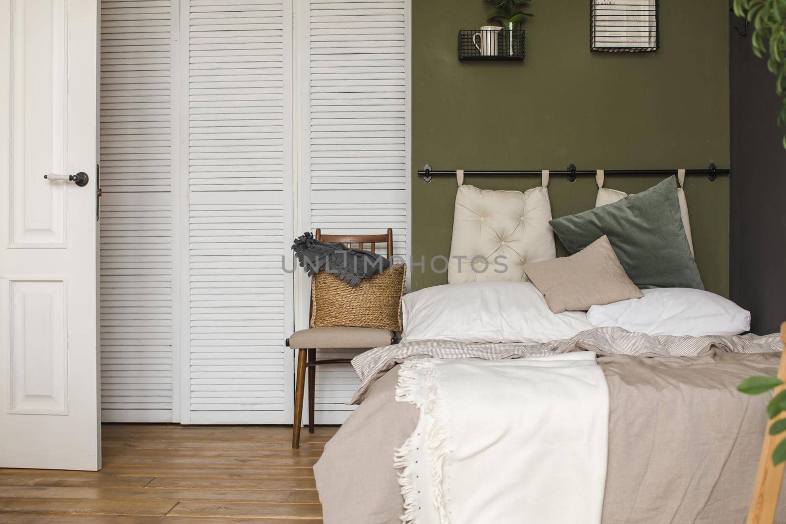 Interior shot of bed with cushions and plaid in simple and cozy design.