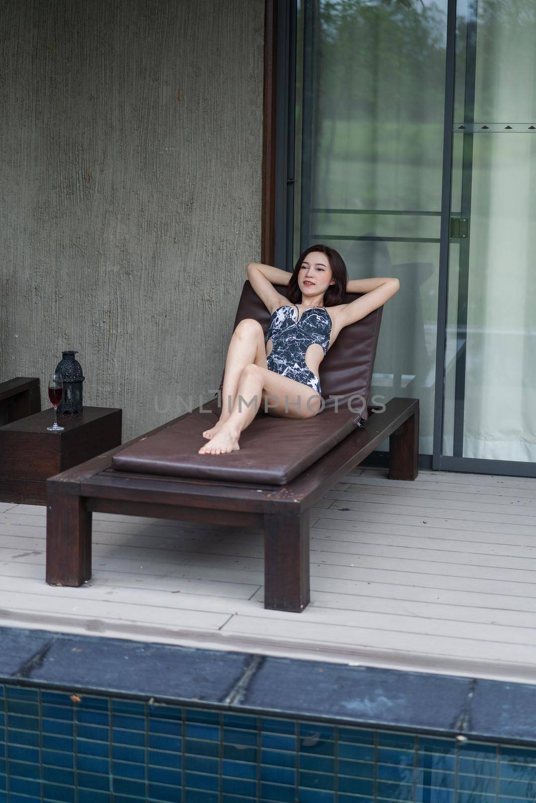 young woman relaxing on a chair at swimming pool