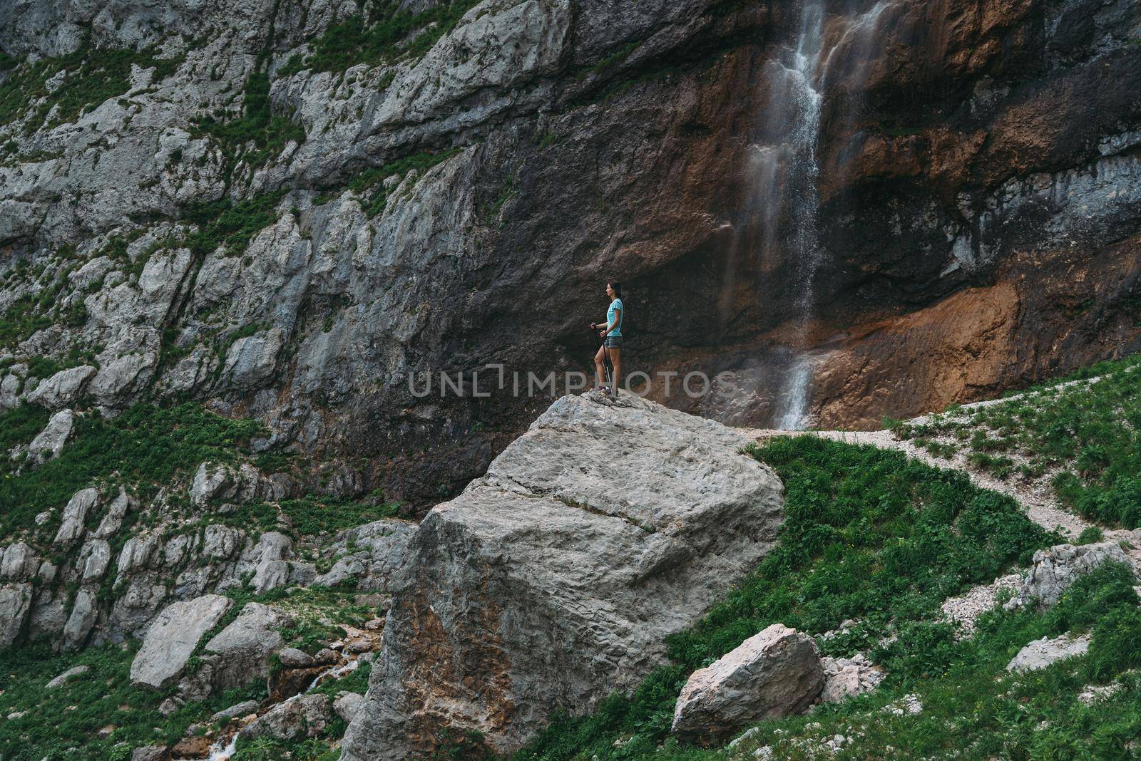 Traveler walking in rocky mountains by alexAleksei