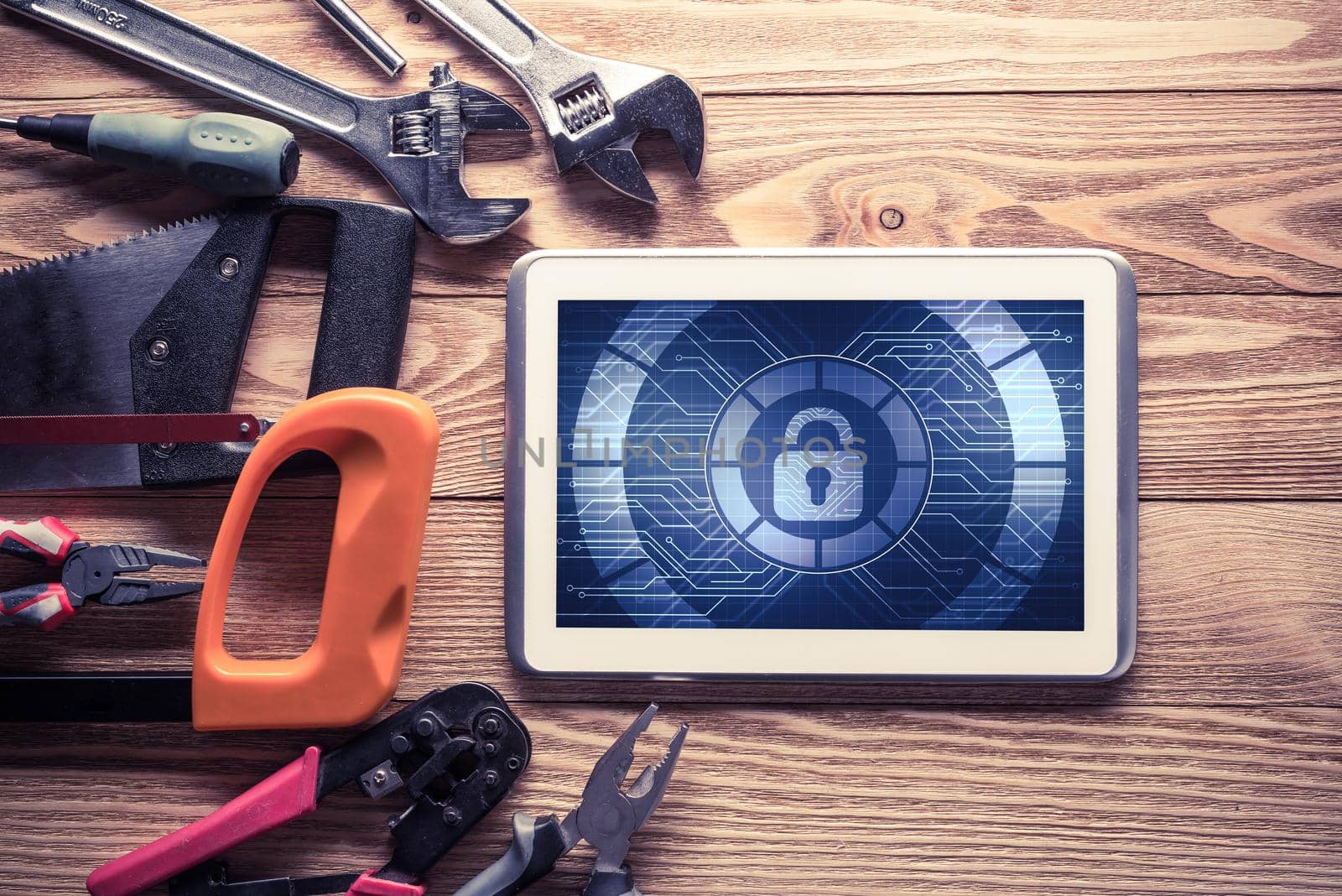 Tablet pc with security concept on screen and industrial tools around