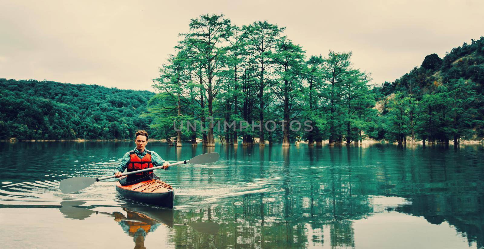 Man rowing in kayak outdoor by alexAleksei