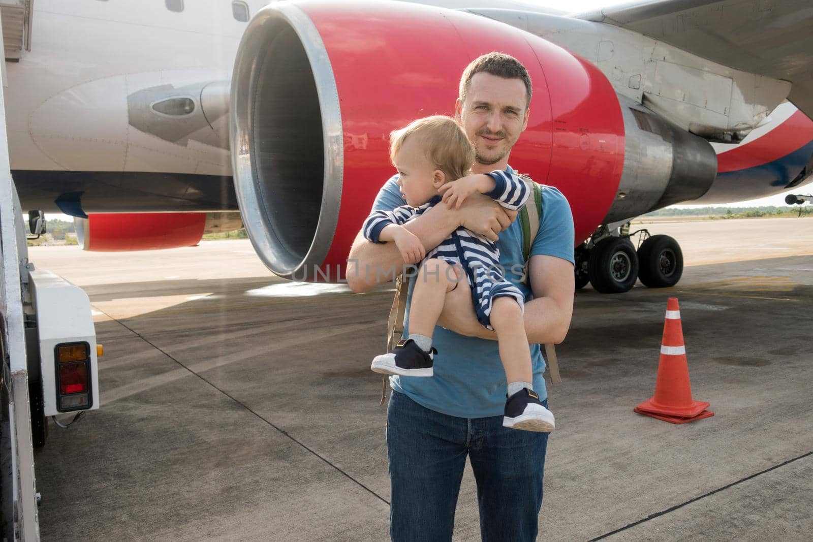 Family Father and child boarding on plane in airport, summer vacation airfield