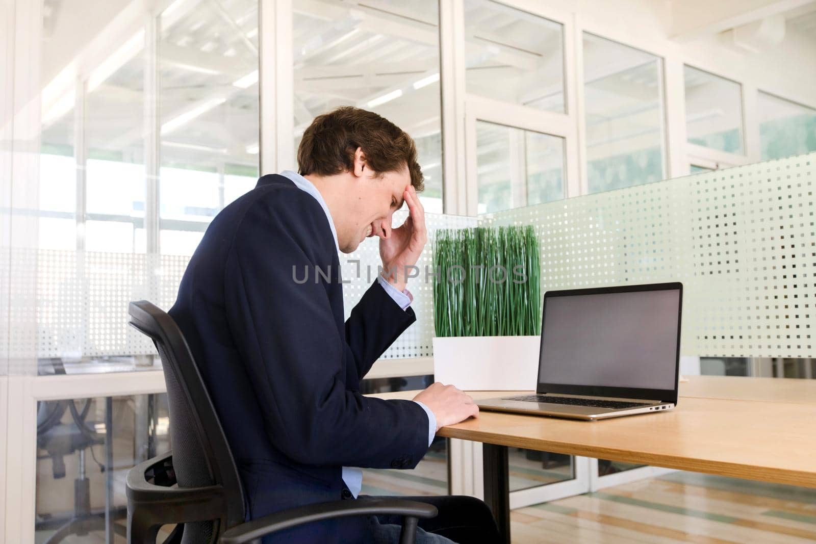 Pensive man using laptop in office by Demkat