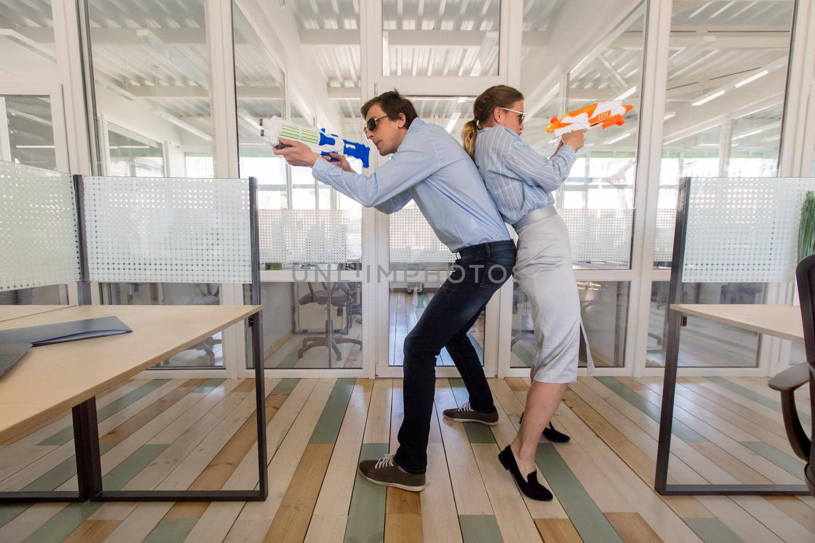Colleagues with toy guns in office by Demkat
