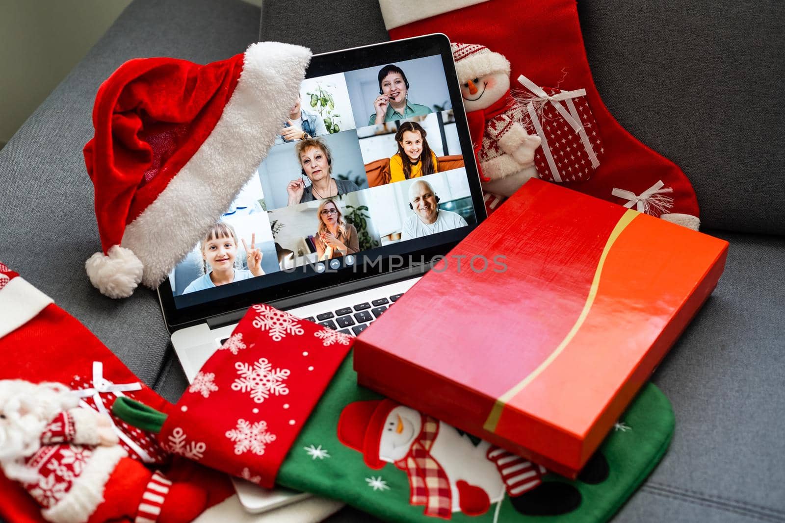 Family online video conference, christmas greetings. Virtual call through screen of laptop, gift. Remote conversation with mom, wife, children. Home isolation.