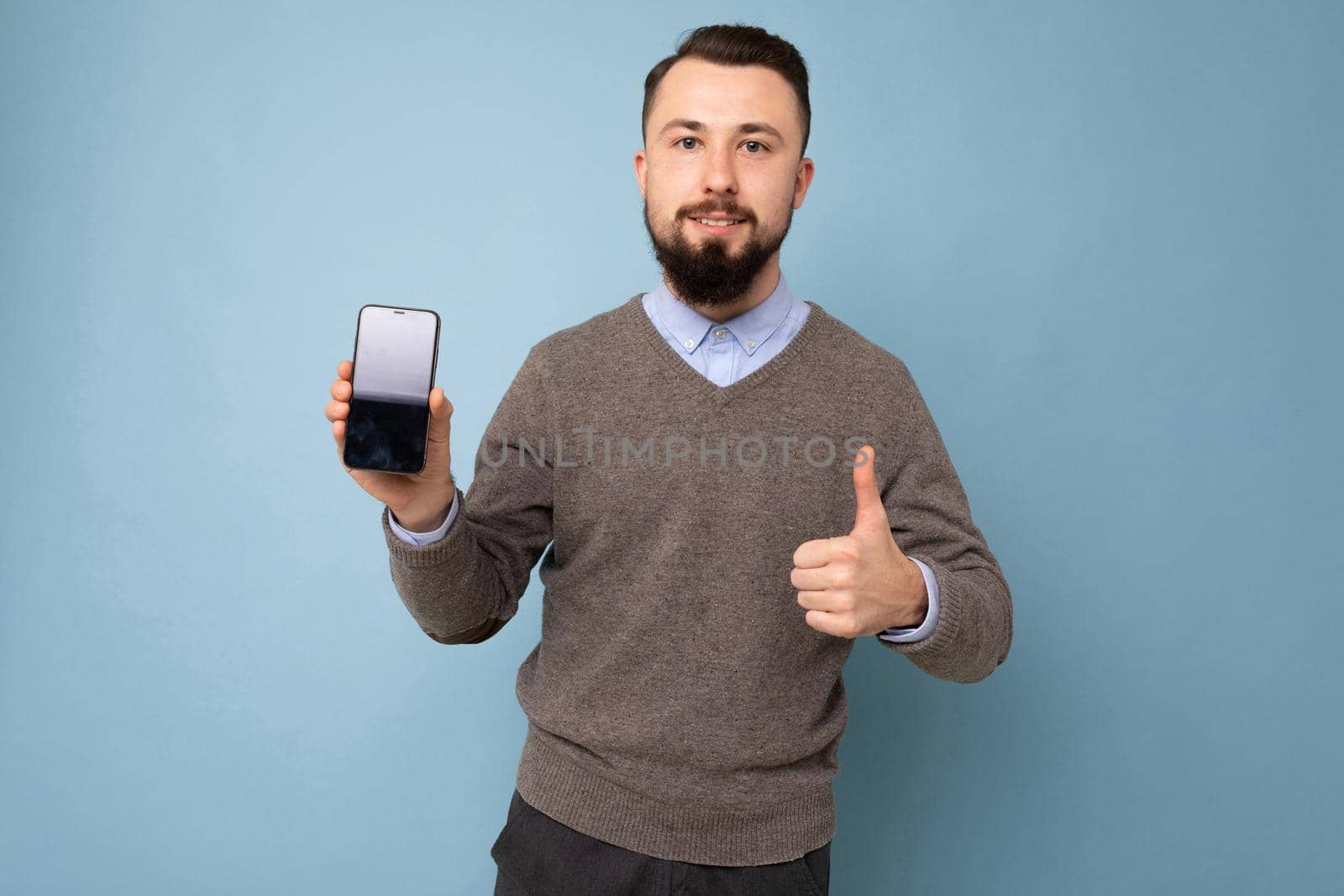 Closeup photo of amazing guy holding modern telephone hands casual outfit isolated on bright blue background.