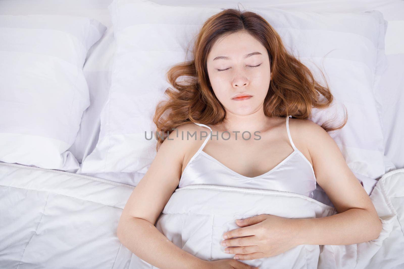 Woman sleeping on bed in the bedroom 