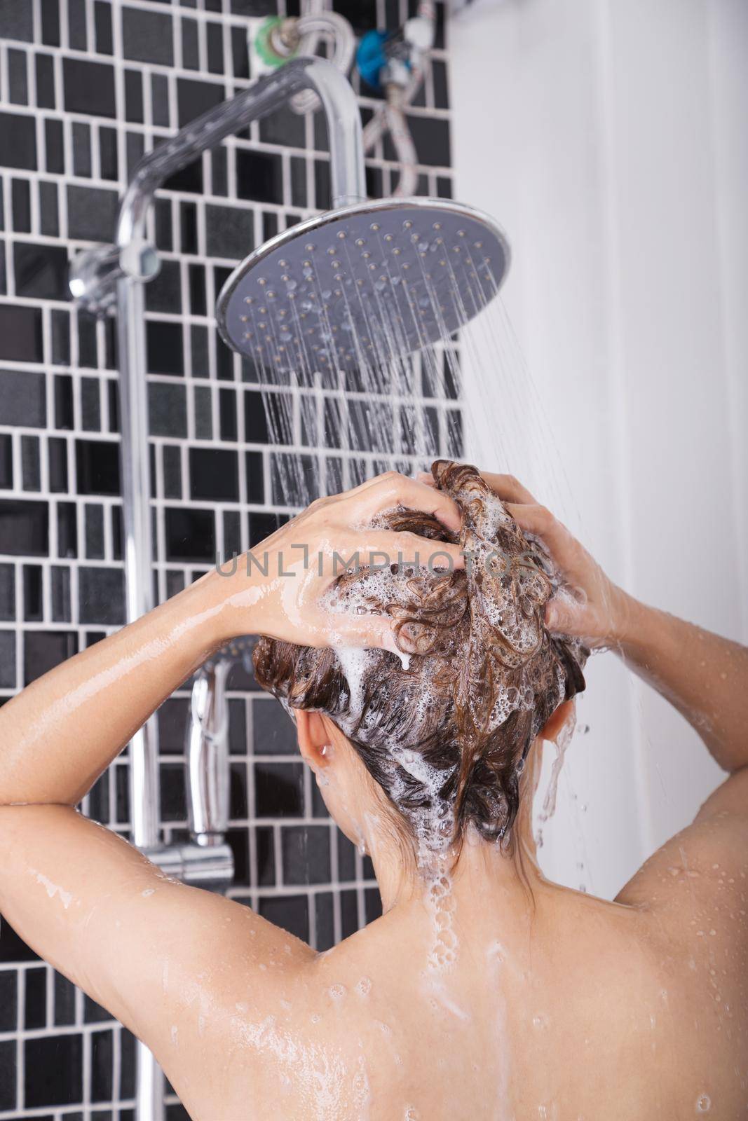 woman washing head and hair in the rain shower by shampoo, rear view by geargodz