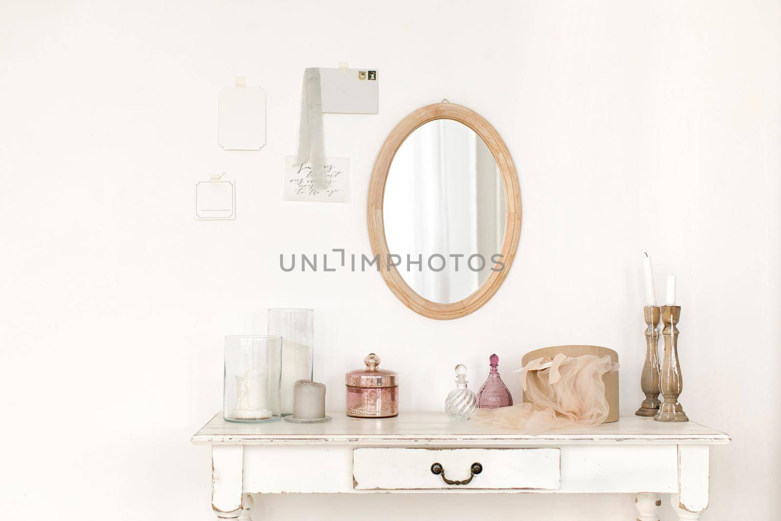 White colored vintage table and mirror hanging on the wall.