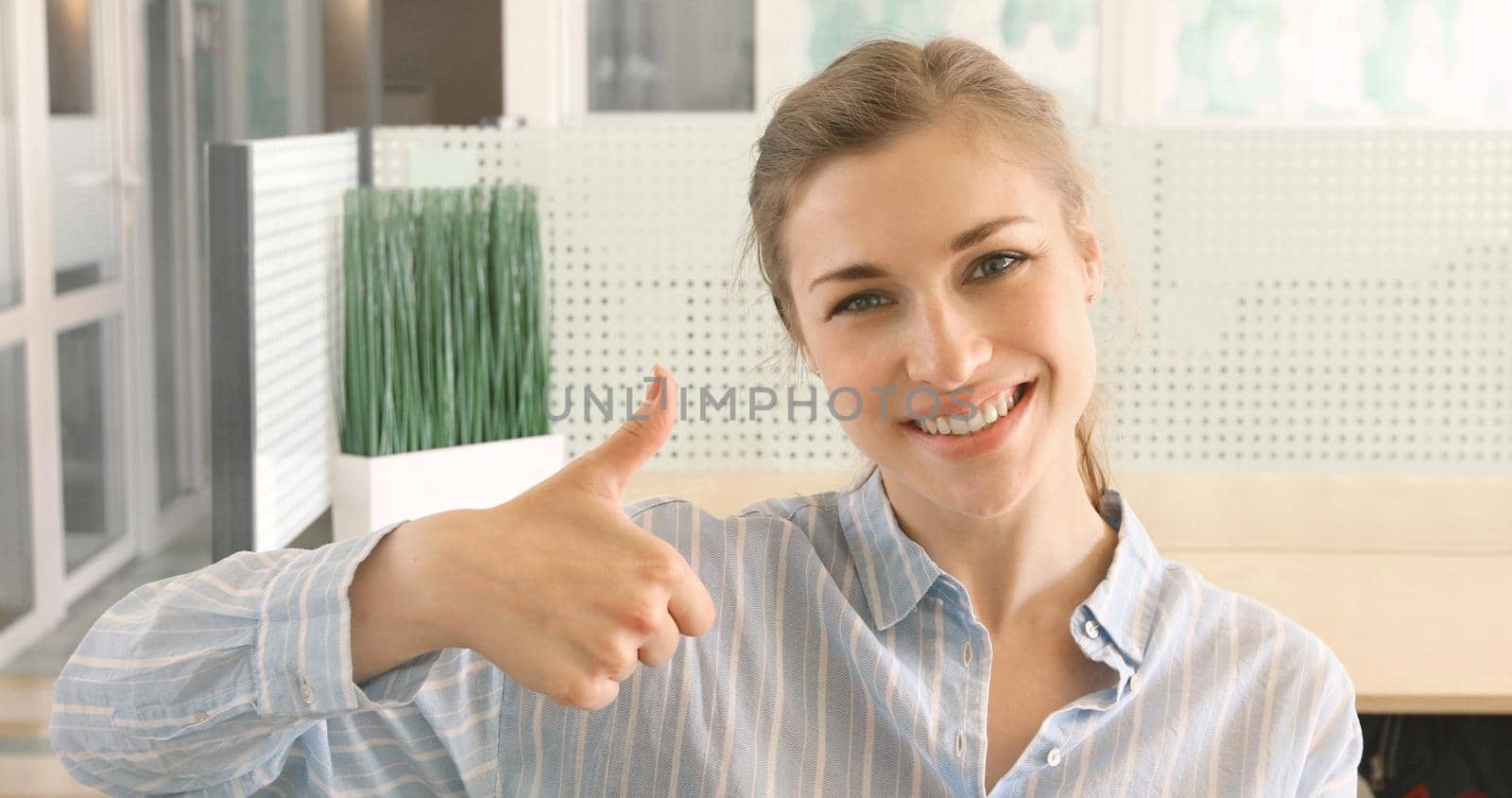 Cheerful girl showing thumb up smiling. Woman smiles shows good gesture