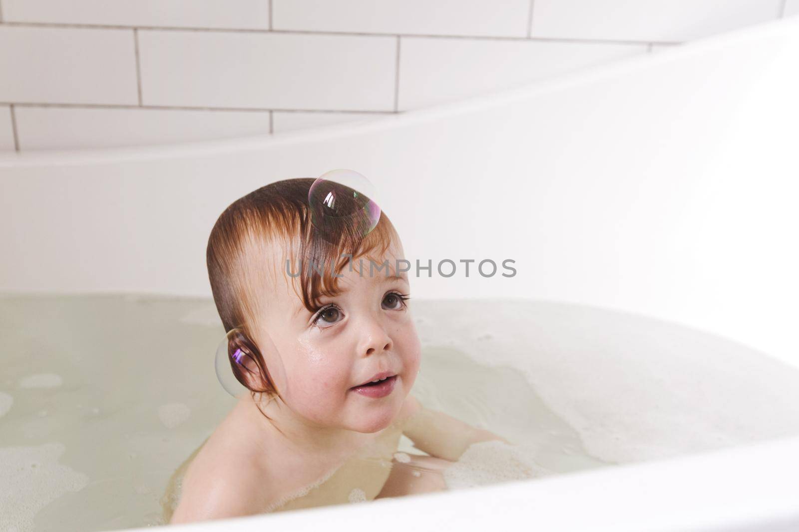 Adorable bath baby boy with soap suds on hair by Demkat