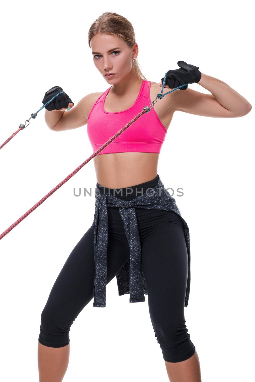 Strong woman using a resistance band in her exercise routine. Young woman performs fitness exercises on white background. Woman with beautiful slim healthy body posing in studio.