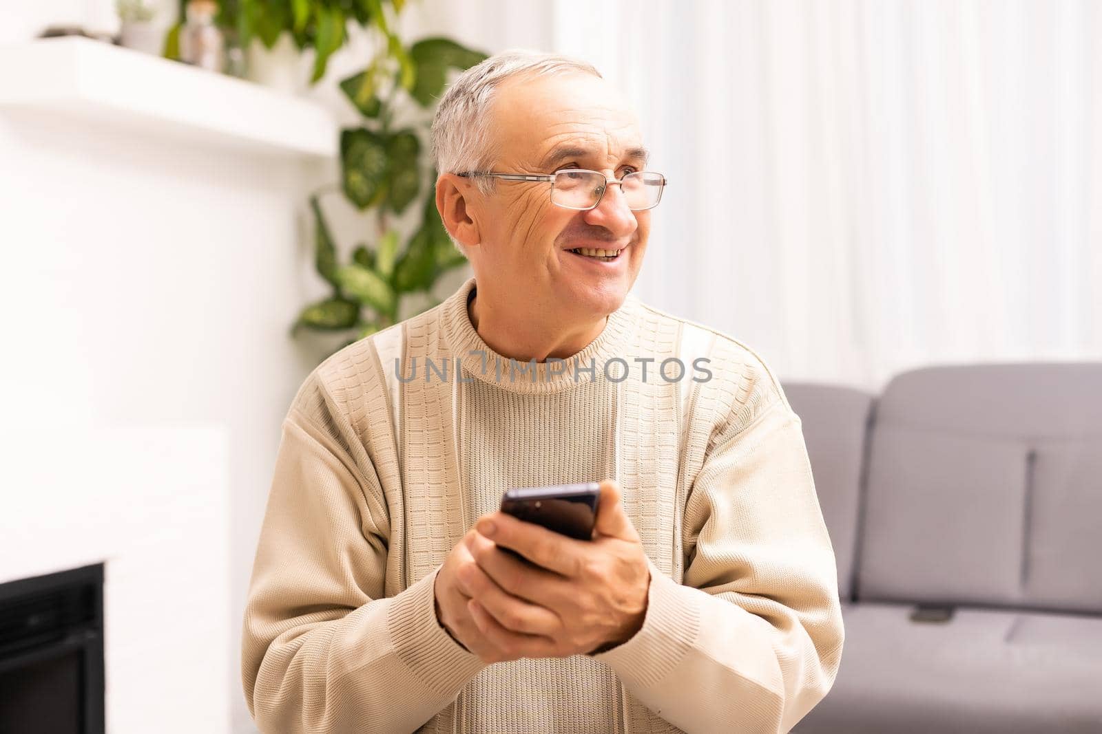 technology, people, lifestyle and communication concept - happy senior man dialing phone number and texting on smartphone at home