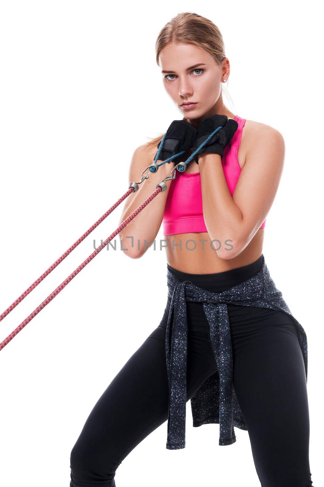 Strong woman using a resistance band in her exercise routine. Young woman performs fitness exercises on white background. Woman with beautiful slim healthy body posing in studio.