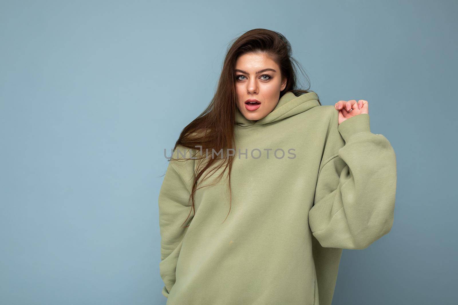 Attractive funny stylish young woman in a khaki hoodie. Mock-up. Copy space.