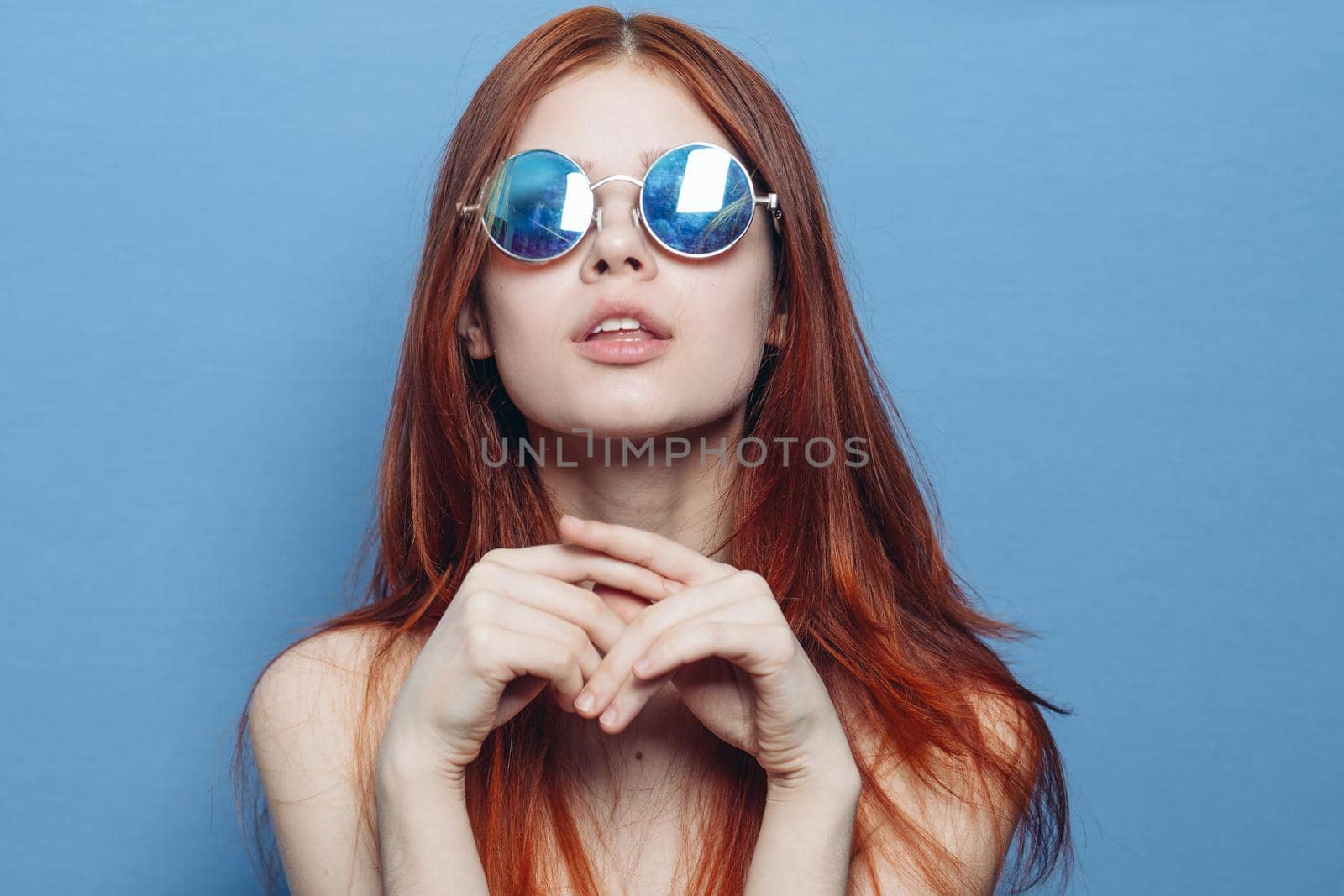 attractive woman with bare shoulders fashionable glasses blue background. High quality photo