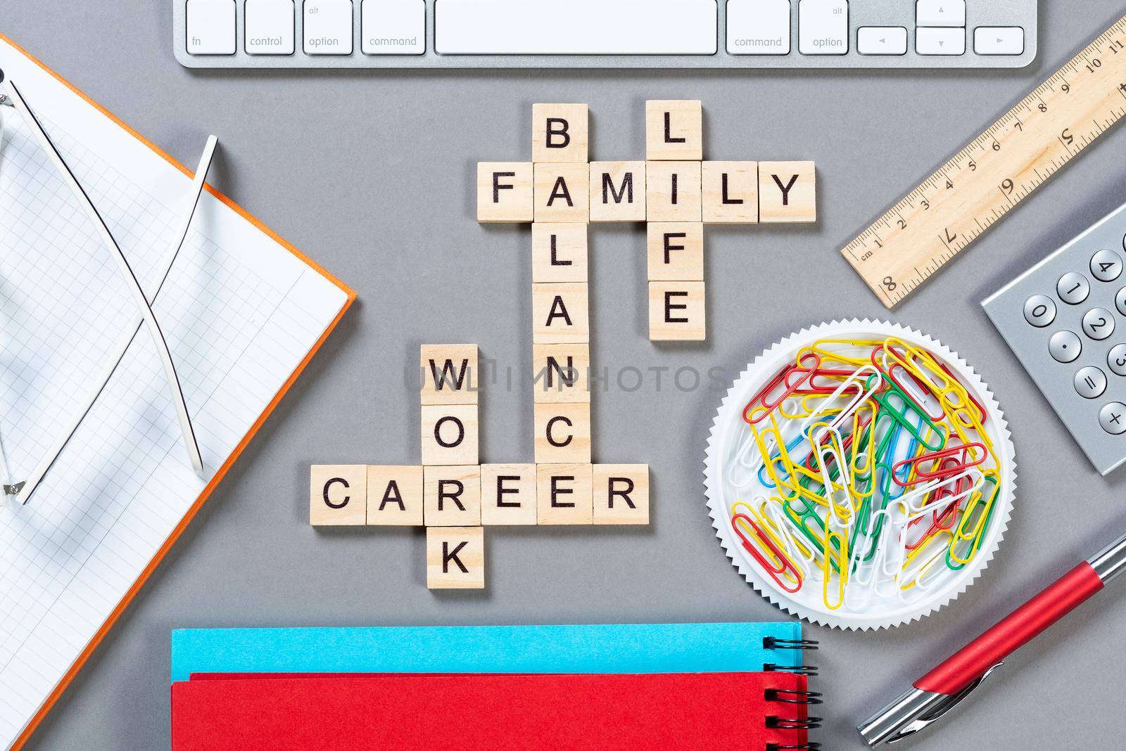 Business motivation concept with words from cubes. Still life of office workplace with crossword. Flat lay grey surface with computer keyboard and stationery. Strategy planning and business analytics.