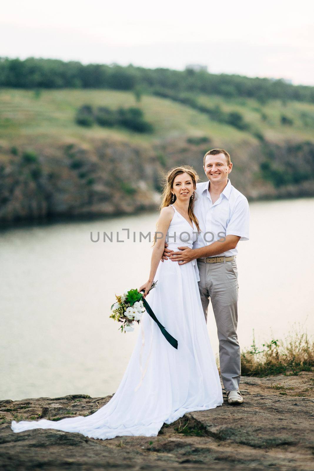 young couple a girl and a guy are walking in the field against the background of the river