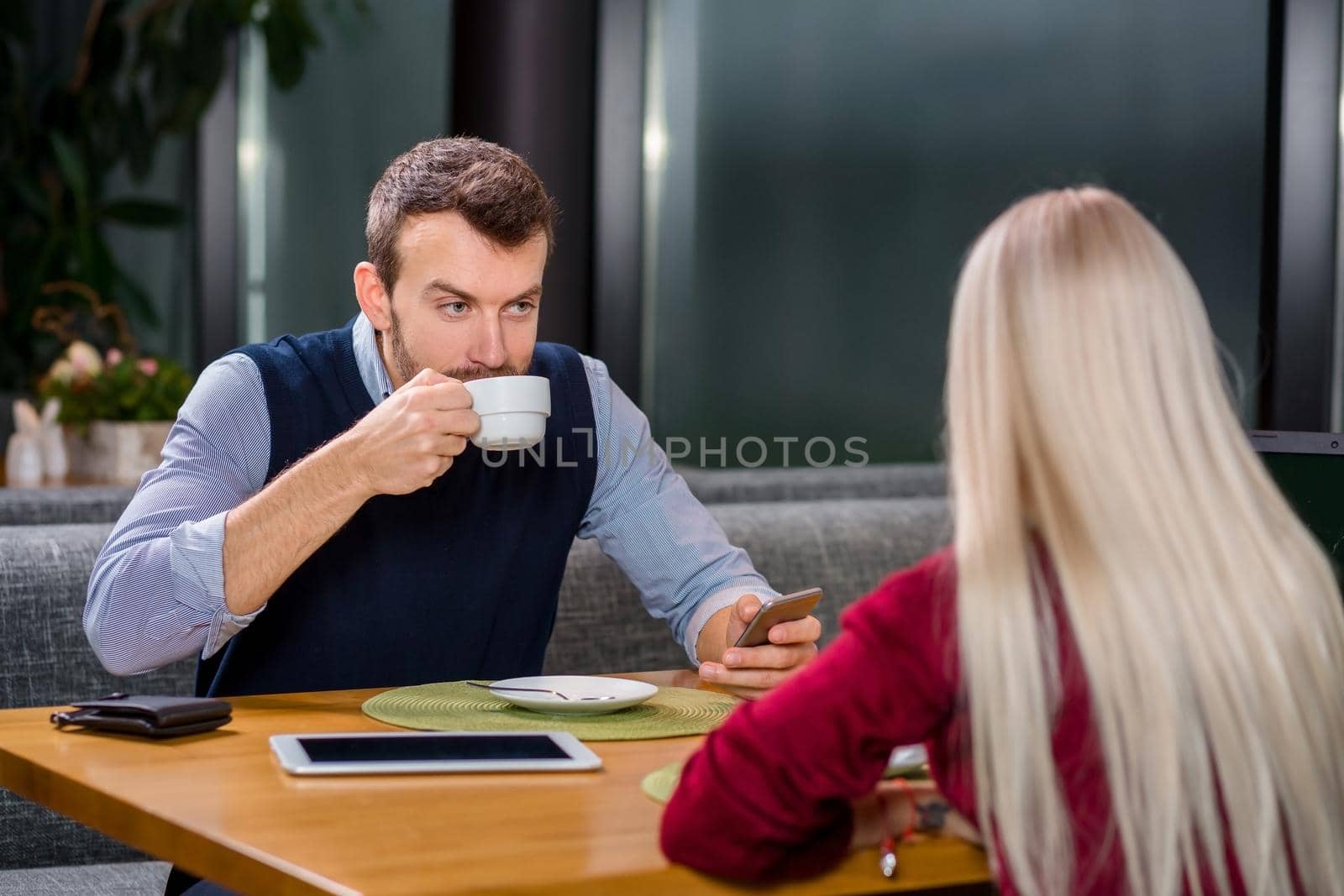 A woman and a man on a business lunch in a restaurant, drink coffee