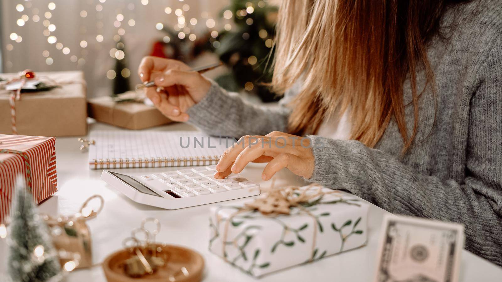 Girl counting US Dollar bills, using calculator, and writing expenses. Woman doing budget, estimating money balance for shopping spree. Female accountant paying taxes. Girl counting Christmas gifts.