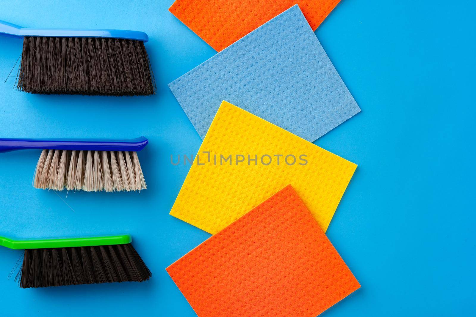 House cleaning supplies on blue color background, top view