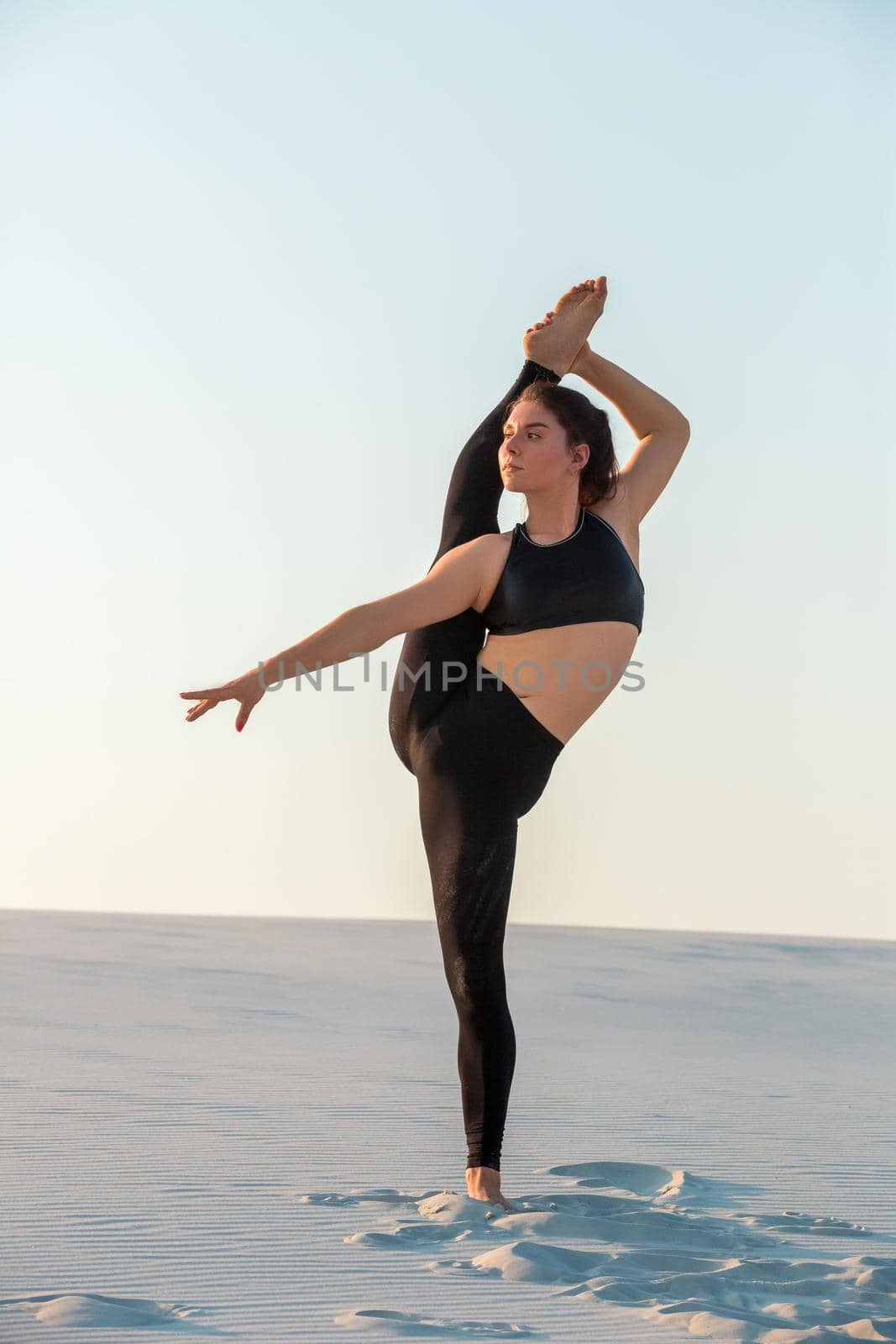 Young professional gymnast woman dance outdoor - sand beach. Fitness, sport, people and lifestyle concept