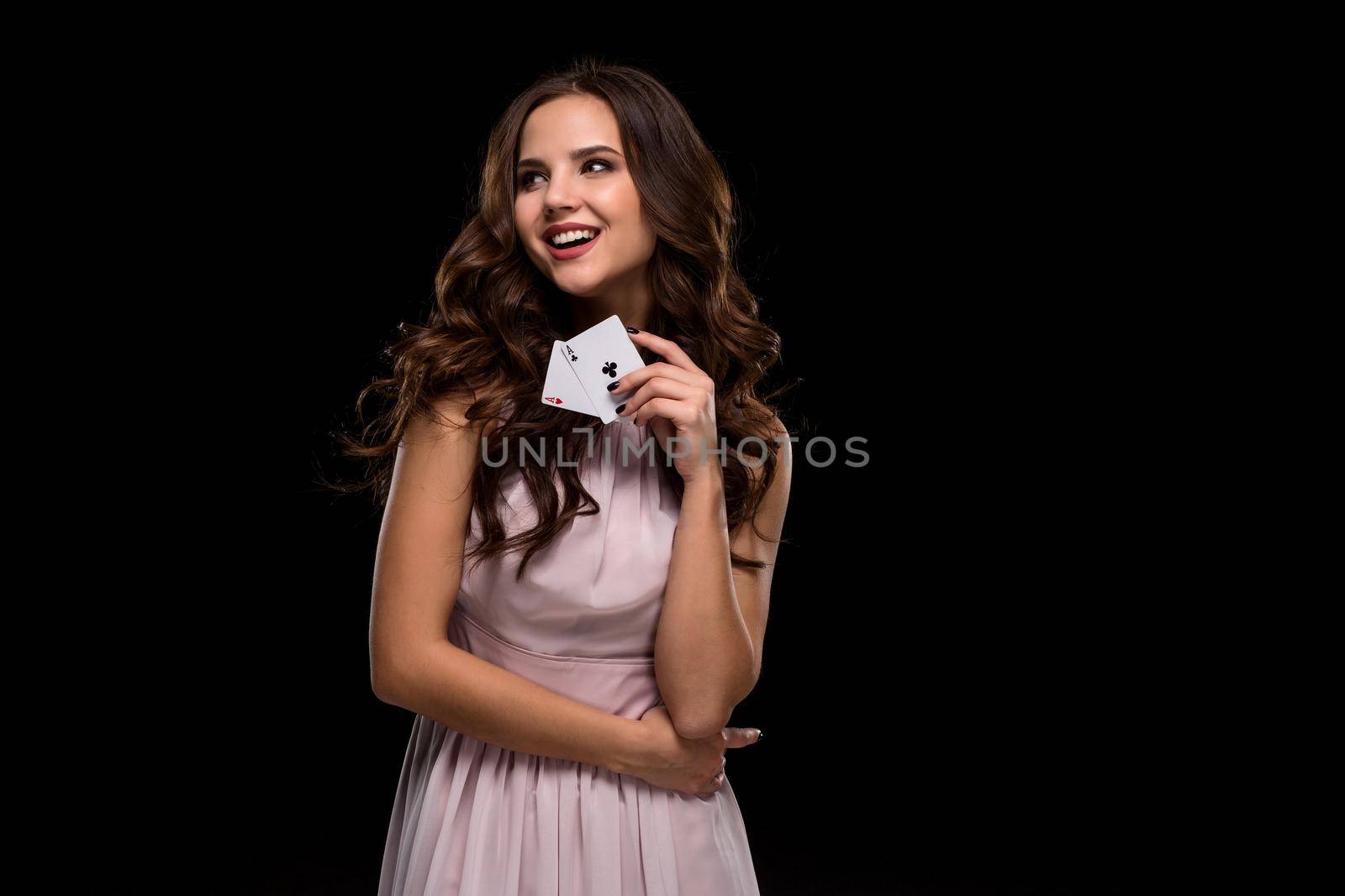 Sexy curly hair brunette posing with casino cards two aces in her hands, poker concept black background. Casino, poker, Roulette Blackjack Spin. Big win. winning combination emotions