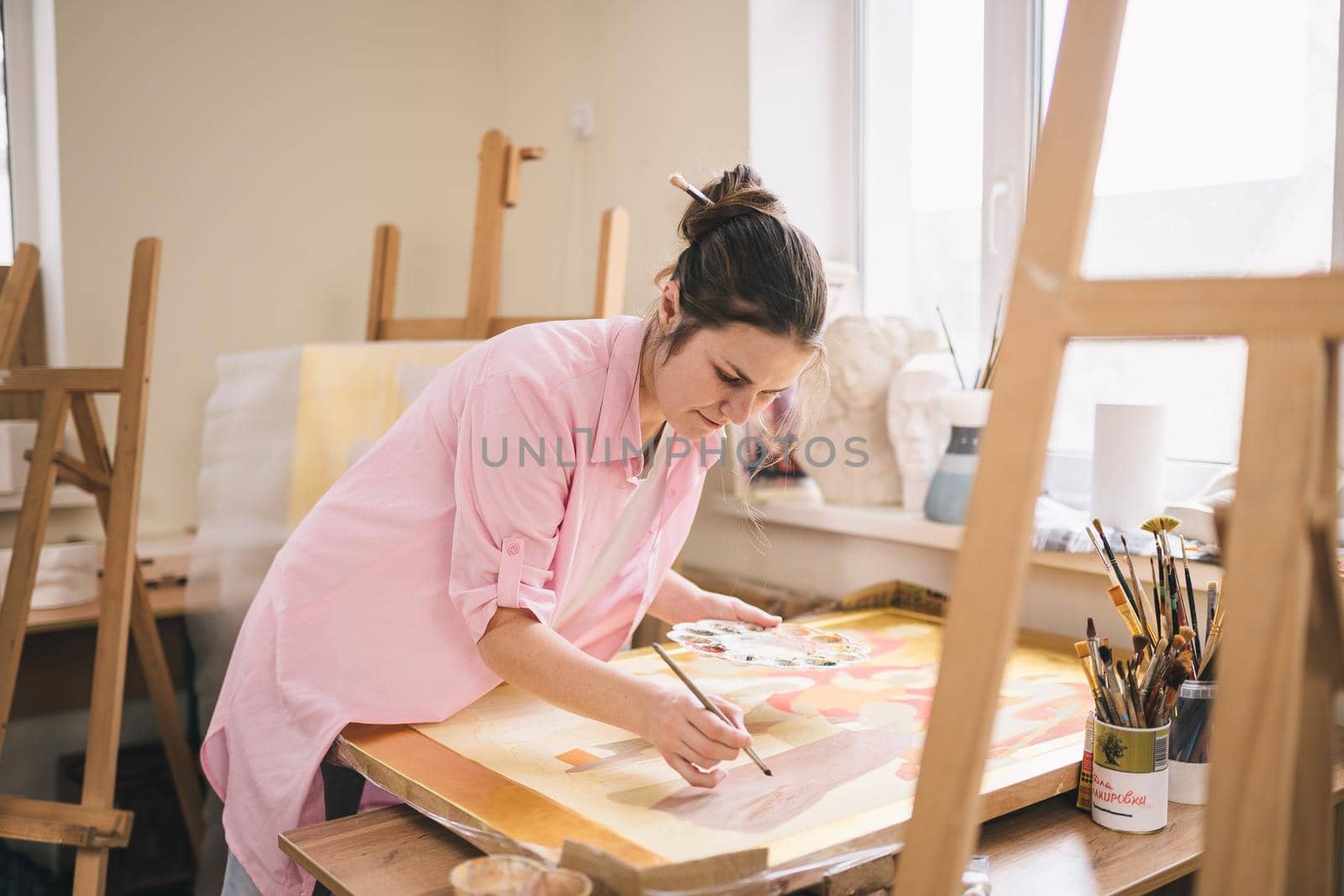 Art, creativity, hobby and creative occupation concept. Bringing creativity to life. Woman painting in art studio. Attractive female artist painting in workshop. Woman hobby, activity, profession.