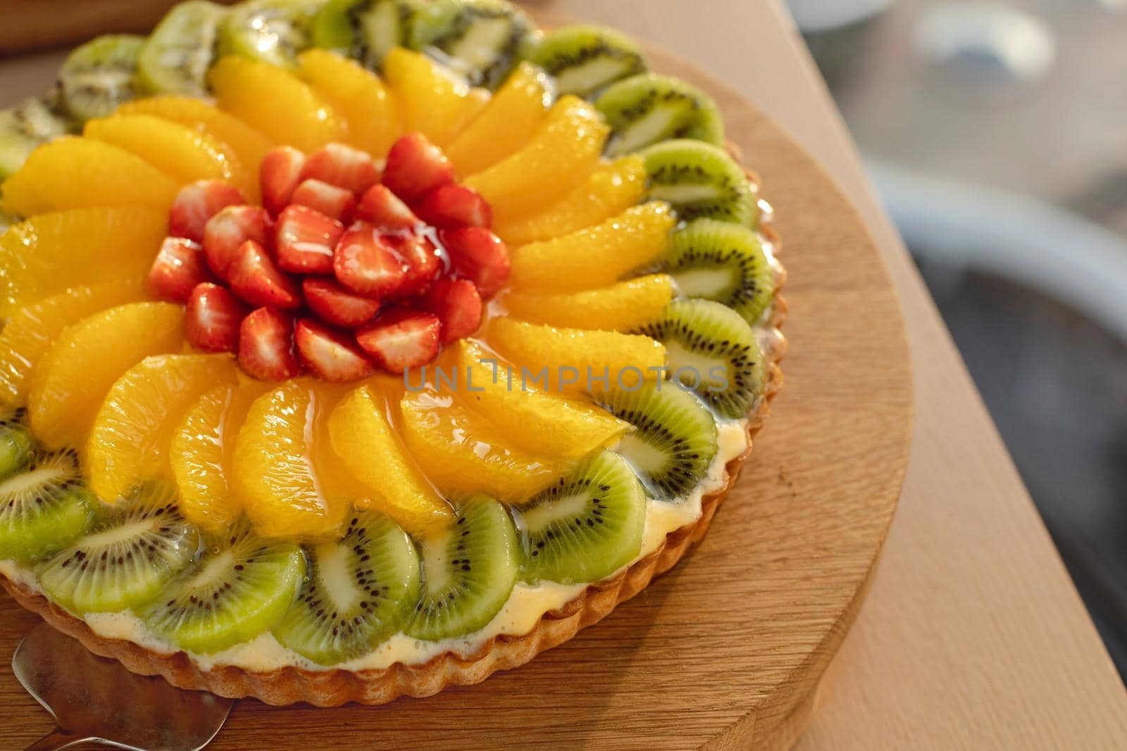 Colourful decorated fruit cake on wooden plate by Demkat