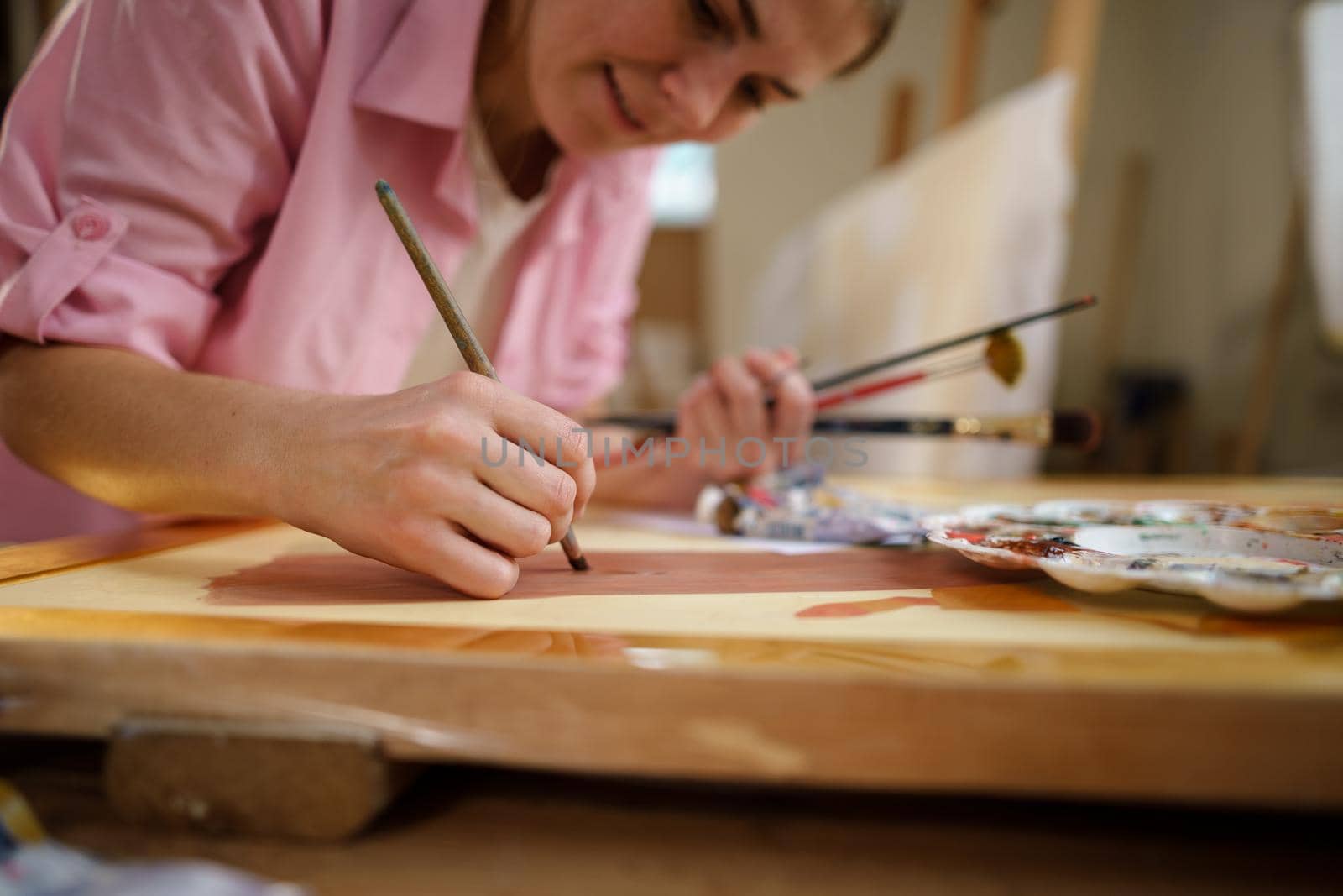 Female artist working in studio. Creative workspace, painting class, easel with canvas, art therapy. Inspiration, creativity, talent, craft concept. Artist studio interior. People, leisure and hobby.