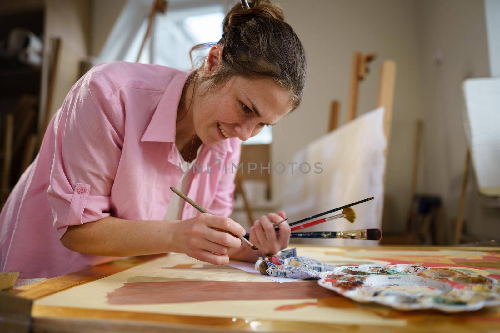 Art, creativity, hobby and creative occupation concept. Bringing creativity to life. Woman painting in art studio. Attractive female artist painting in workshop. Woman hobby, activity, profession.